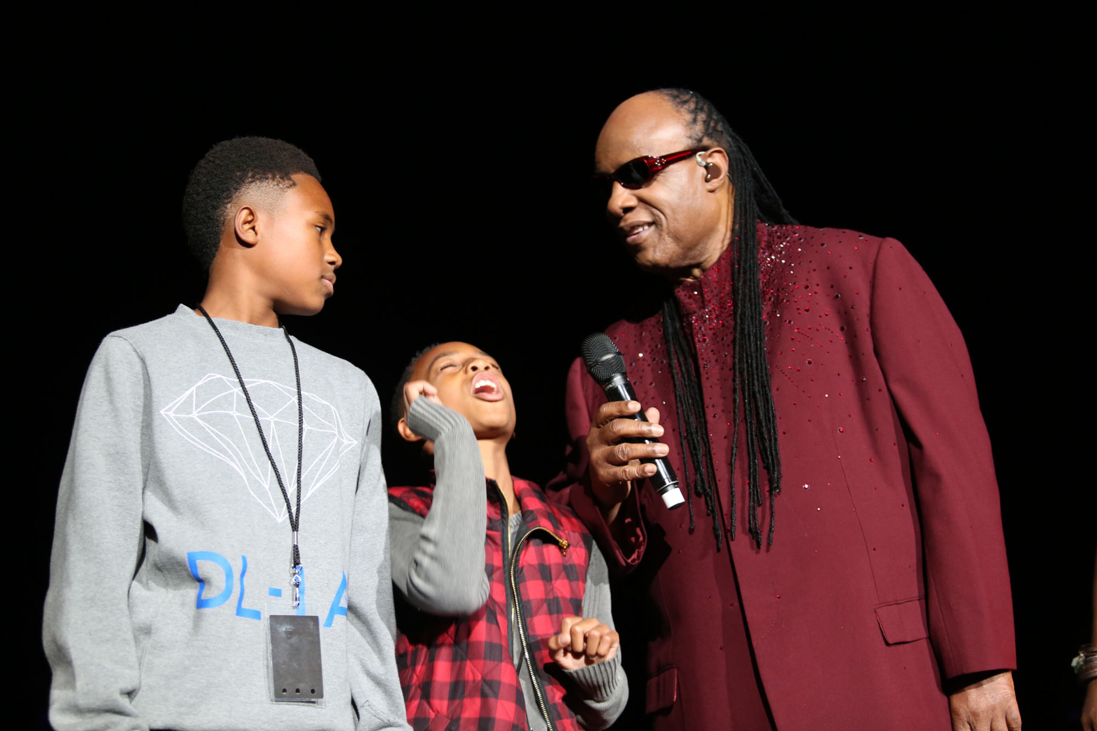 Stevie Wonder shares a light moment with his sons before the start of his performance celebrating his landmark album, "Songs in the Key of Life," to a sold-out audience at Philips Arena. (Akili-Casundria Ramsess/Special to the AJC)