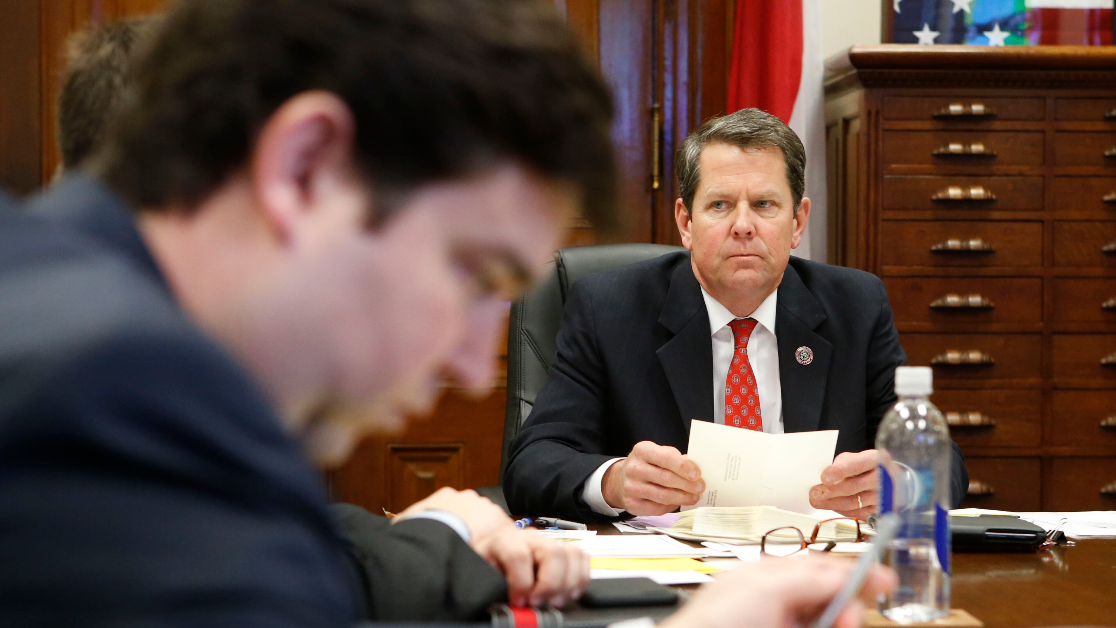 Brian Kemp in a staff meeting at his office in the Capitol. BOB ANDRES / BANDRES@AJC.COM