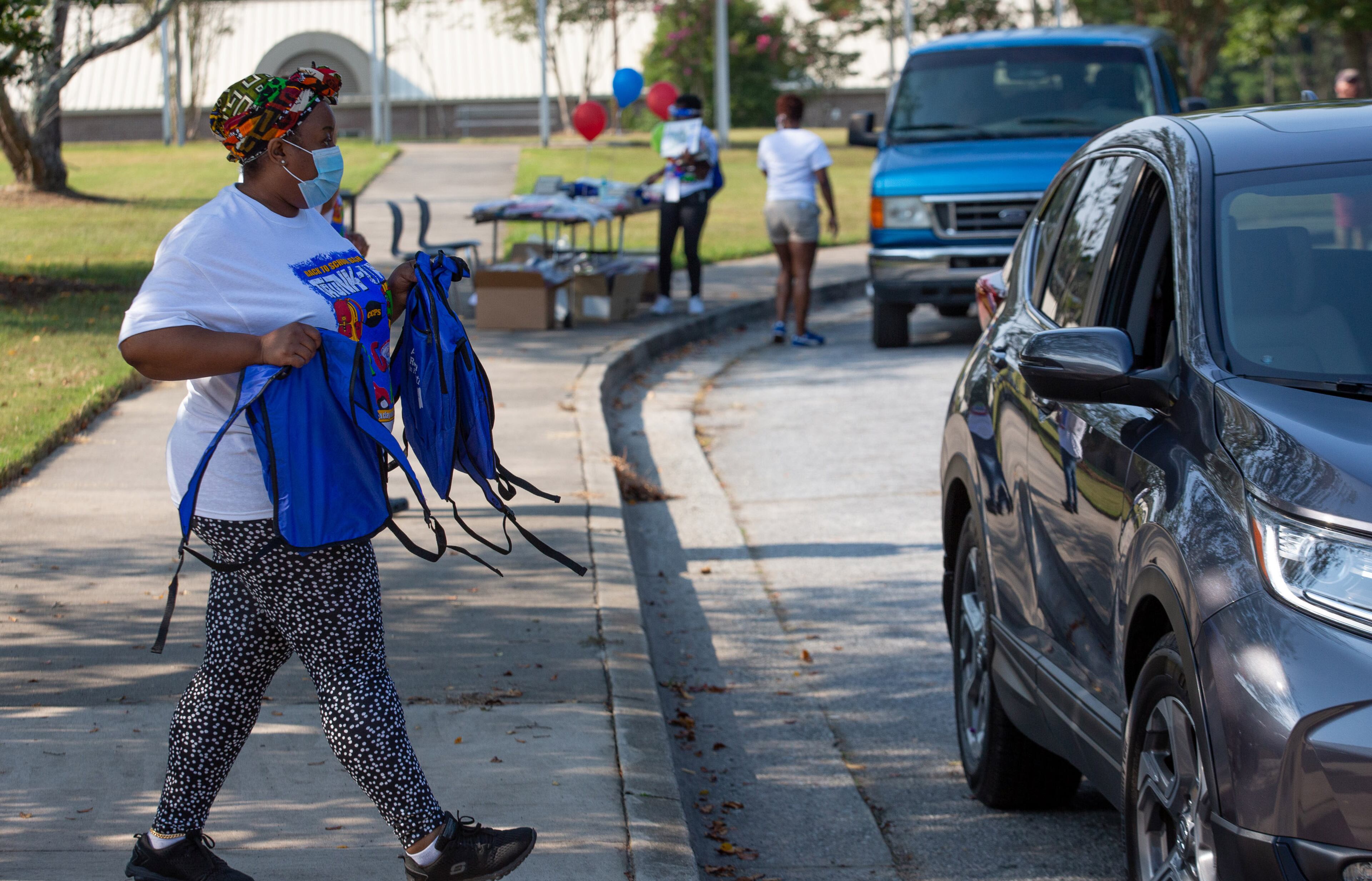 Teacher Trava Davis hands out free backpacks and other schools supplies at Kemp Elementary in Hampton, Georgia on August 8, 2020. STEVE SCHAEFER FOR THE ATLANTA JOURNAL-CONSTITUTION