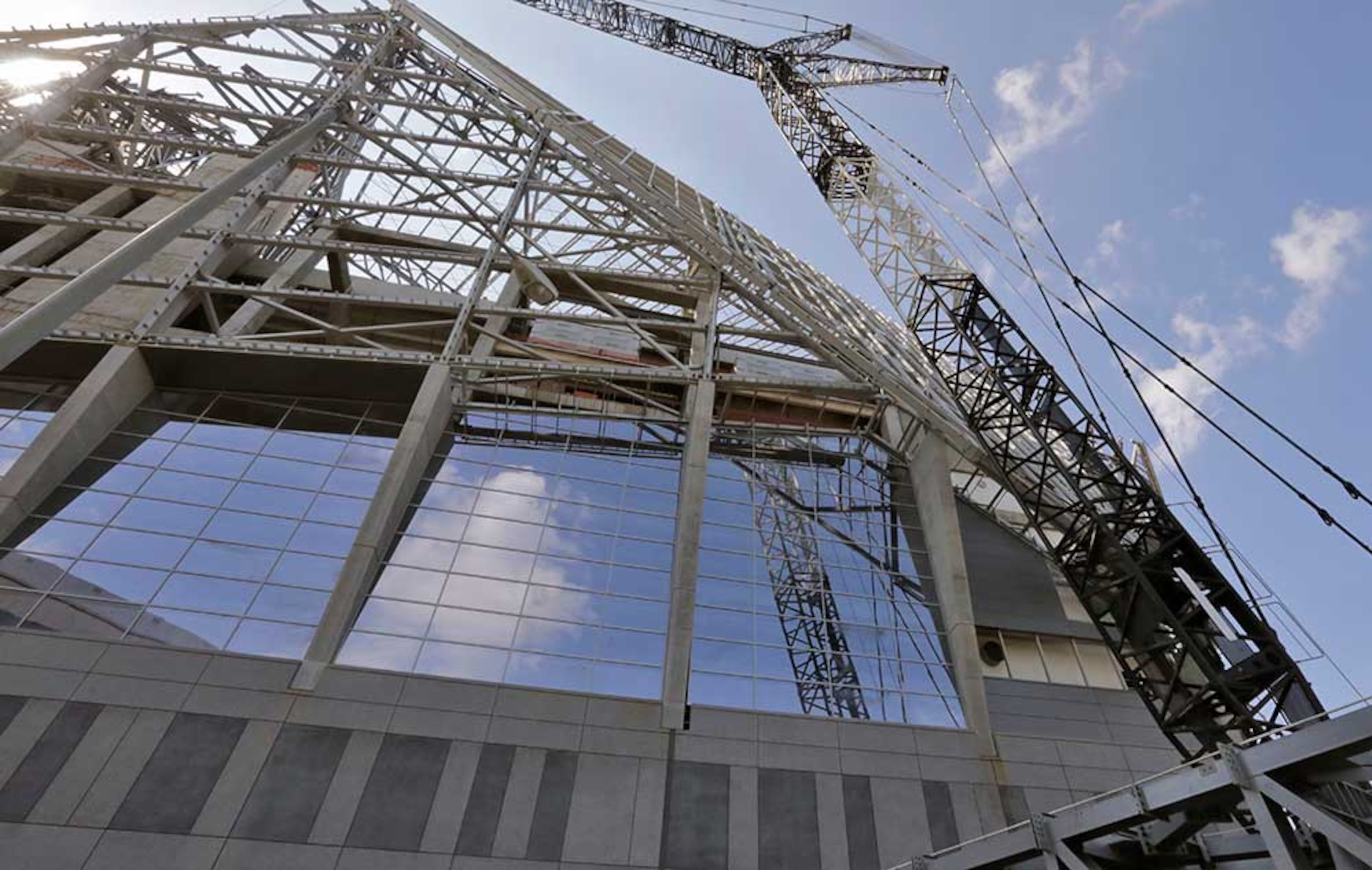 In this exterior view, erection of the facade steel and metal panels is advancing around the exterior of the stadium.