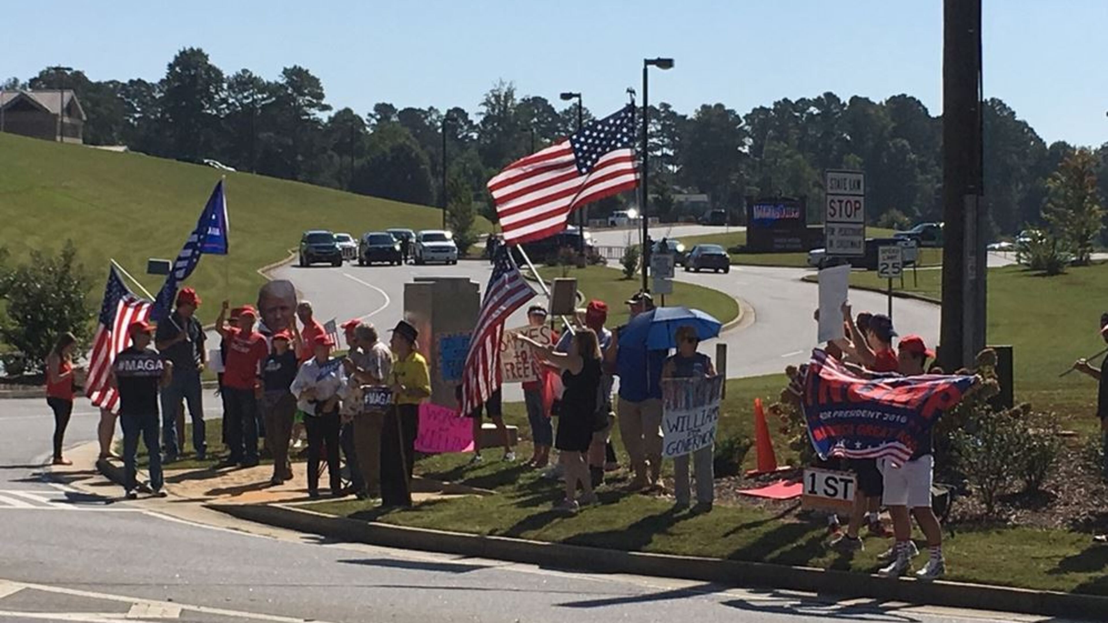 A group of protesters gathered Wednesday near River Ridge High School in Cherokee County. ELLEN ELDRIDGE / ELLEN.ELDRIDGE@AJC.COM