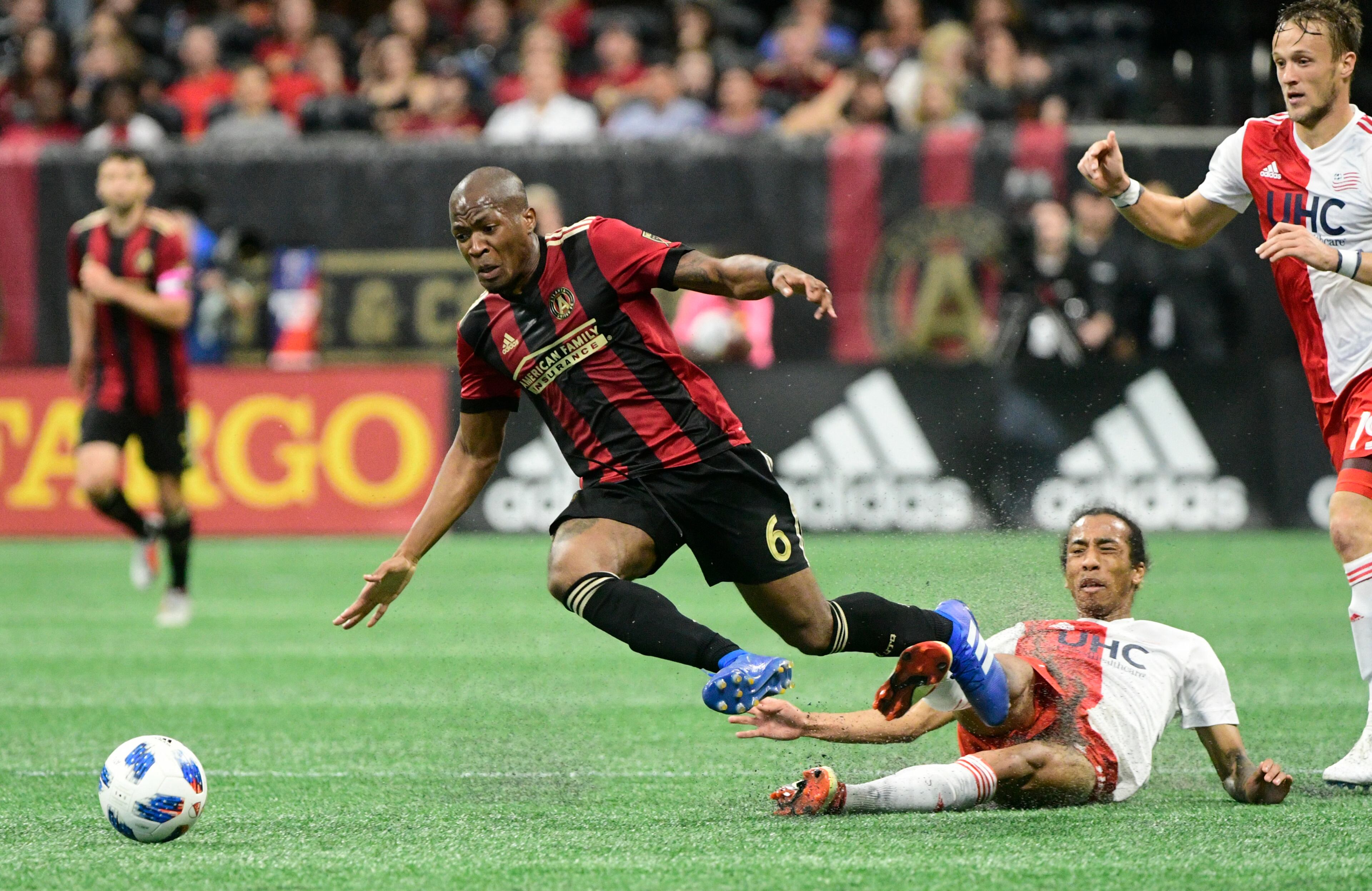Atlanta United midfielder Darlington Nagbe (6) gets tripped up against the New England Revolution during the first half of an MLS soccer game, Saturday, Oct. 6, 2018. (John Amis)