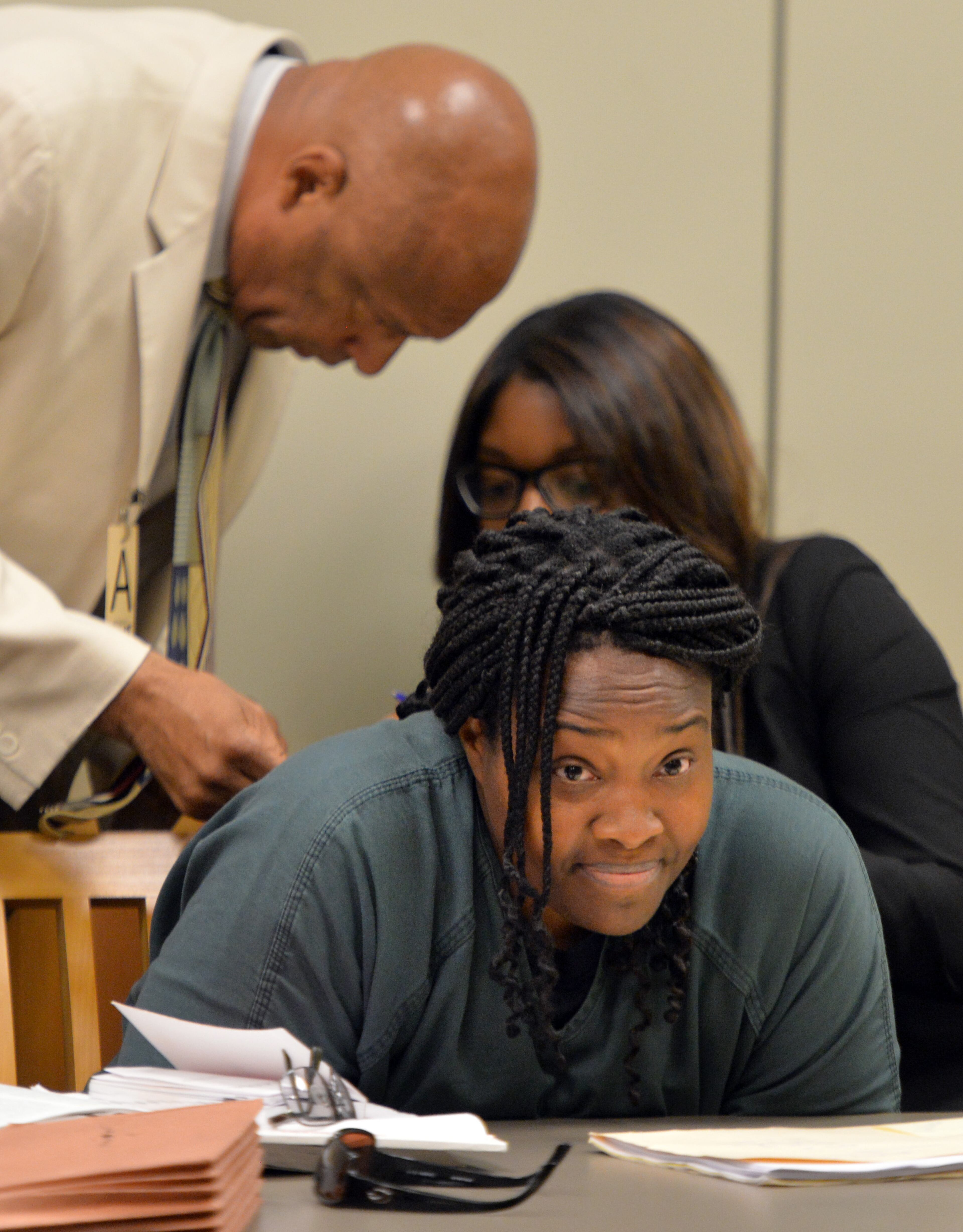 July 10, 2014 Lawrenceville - Defense attorneys Dwight Thomas (left) and Otanya Clarke confer as Therian Wimbushat (cetner) sits during a hearing before Gwinnett chief magistrate Christina Blum at Gwinnett Magistrate Court in Lawrenceville on Thursday, July 10, 2014. Bond has been denied for Recardo and Therian Wimbush being held on child cruelty charges that they kept their oldest child a prisoner in their home. HYOSUB SHIN / HSHIN@AJC.COM