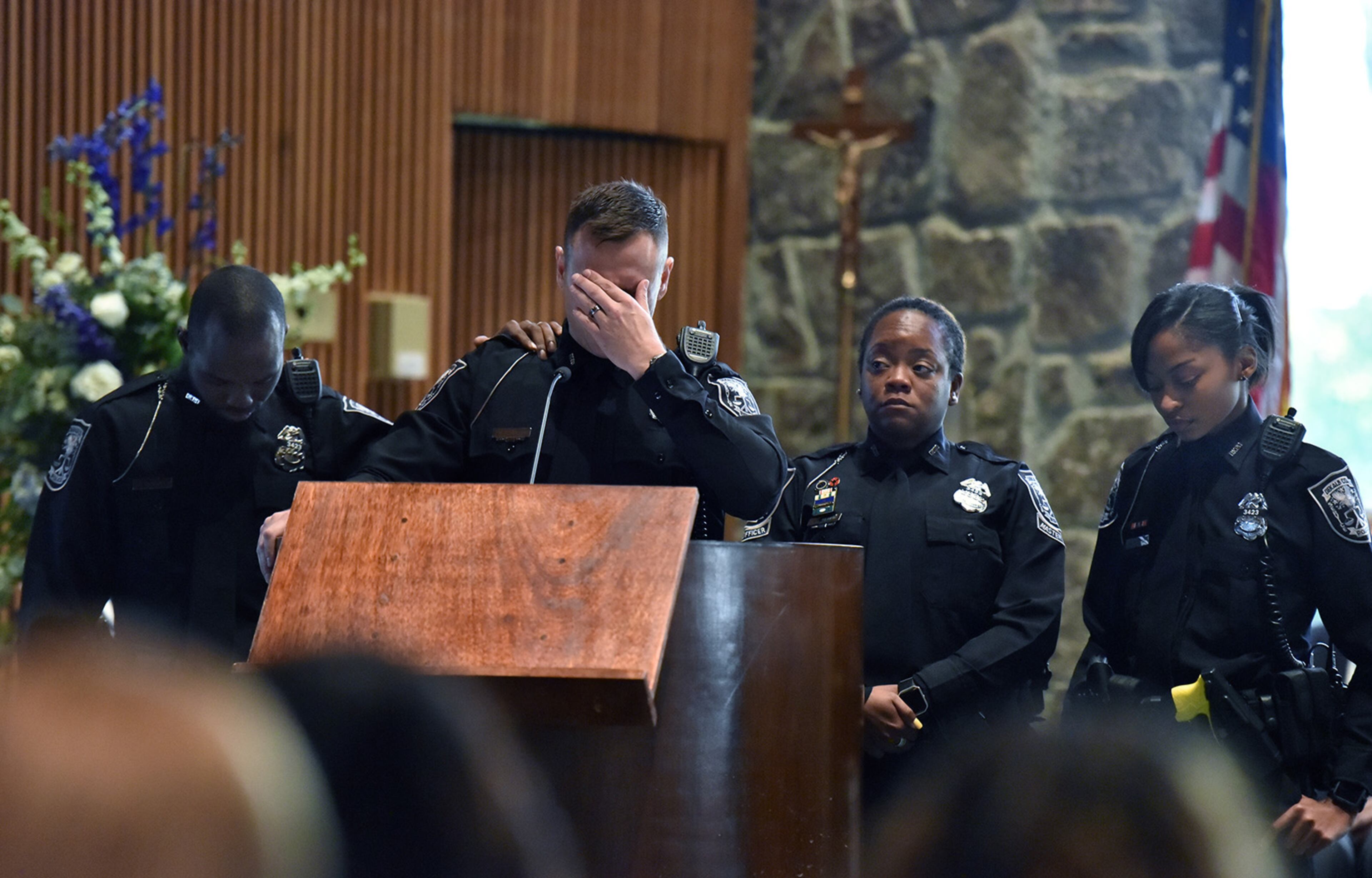 December 18, 2018 Dunwoody - DeKalb County police officers react as they speak during the funeral service of officer Edgar Isidro Flores at All Saints Catholic Church in Dunwoody on Tuesday, December 18, 2018. Flores was shot and killed in DeKalb County in the line of duty last week. HYOSUB SHIN / HSHIN@AJC.COM