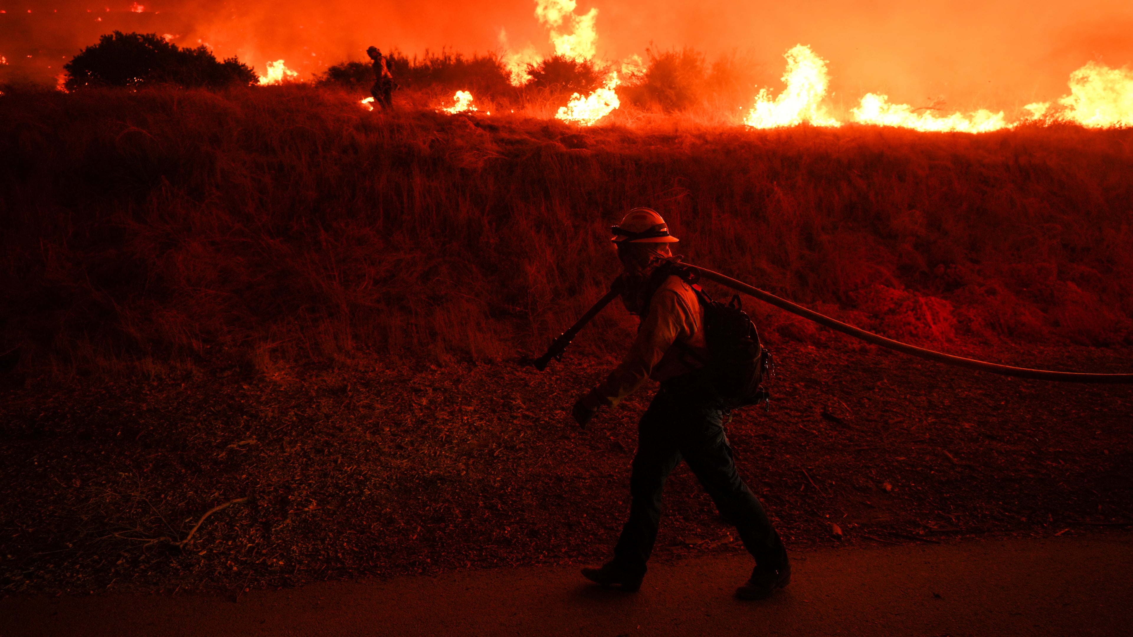 FILE - A firefighter monitors flames caused by the Hughes Fire along Castaic Lake in Castaic, Calif., Jan. 22, 2025. (AP Photo/Jae C. Hong, File)