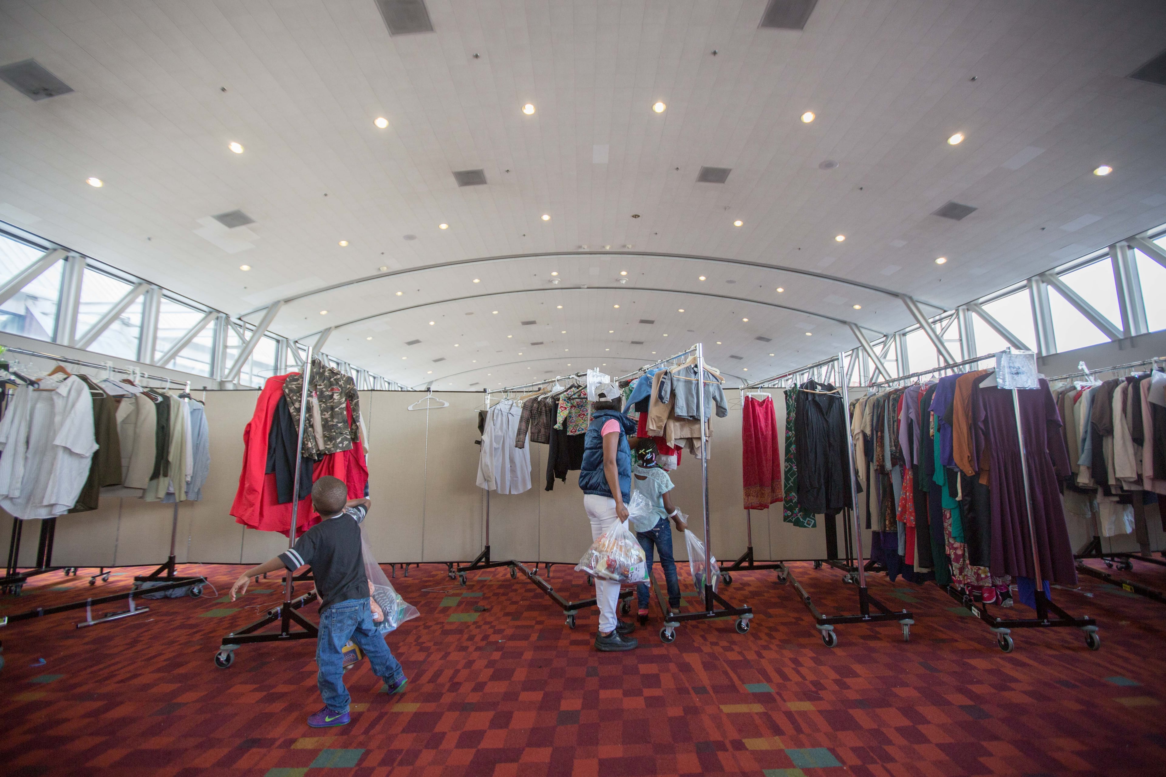 A family looks at clothing during the annual Hosea Feed the Homeless Christmas at the Georgia World Congress Center on Christmas Day, Friday, Dec. 25, 2015, in Atlanta. BRANDEN CAMP/SPECIAL