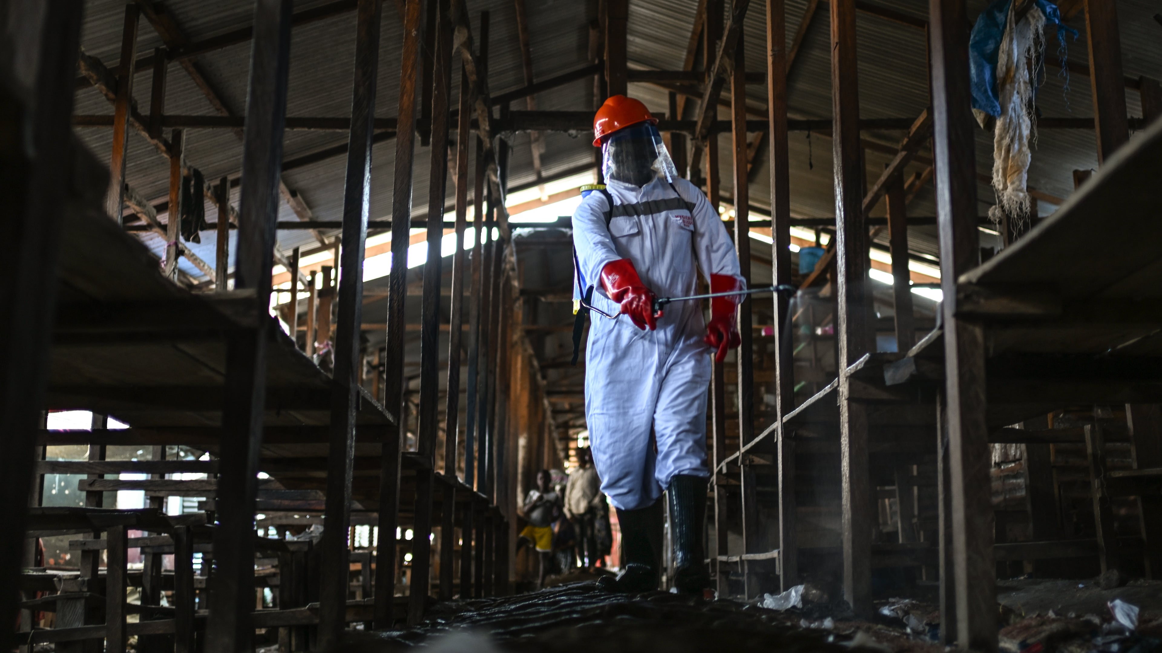 A sanitation worker from the Bunia city government sprays chlorine to disinfect the central market, as Ituri province continues to combat an Ebola outbreak, in Bunia, Congo, Saturday, May 23, 2026. (AP Photo/Moses Sawasawa)