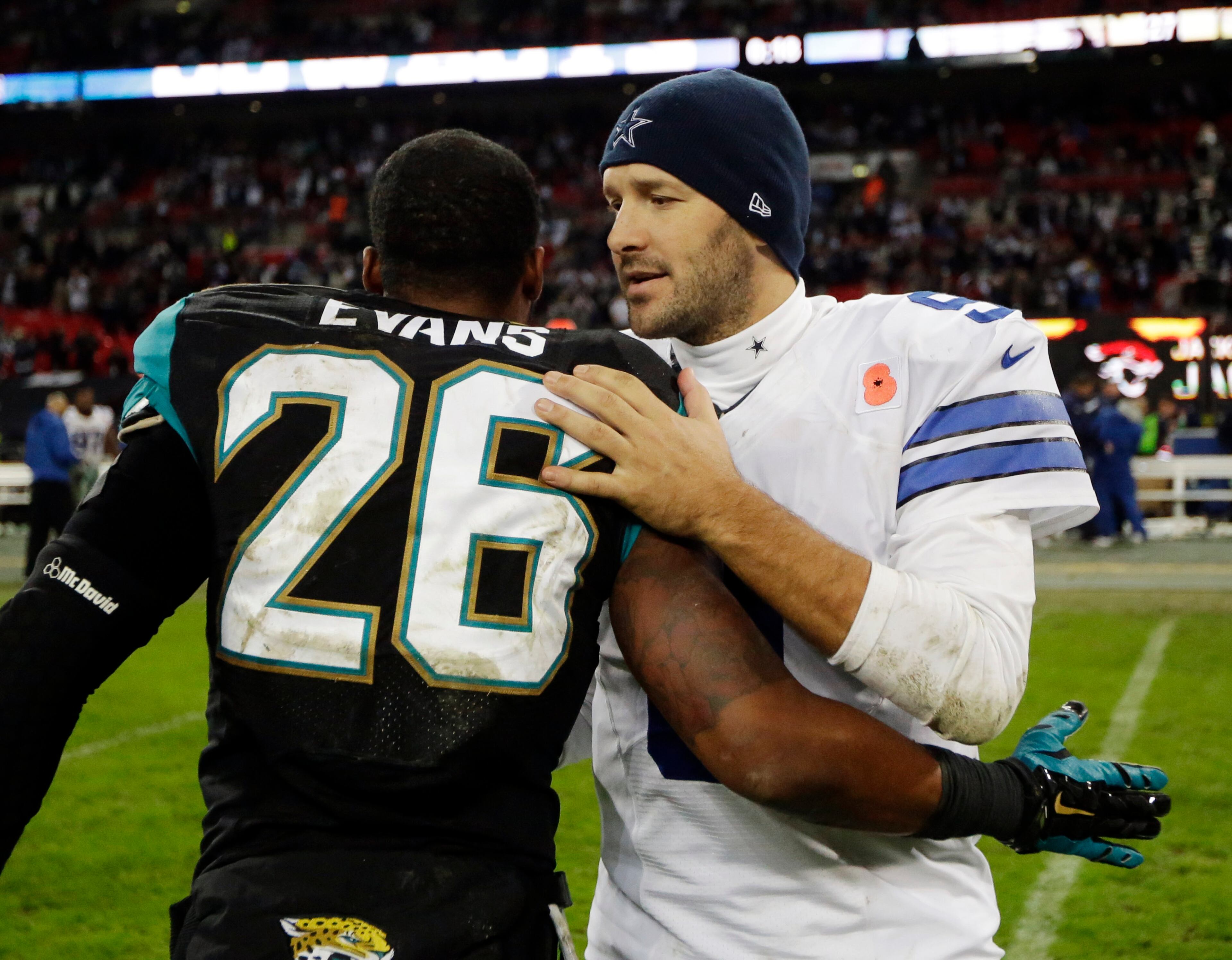 Dallas Cowboys quarterback Tony Romo talks to Jacksonville Jaguars free safety Josh Evans (26) following their NFL football game at Wembley Stadium, London, Sunday, Nov. 9, 2014. The Cowboys defeated the Jaguars 31-17. (AP Photo/Matt Dunham)