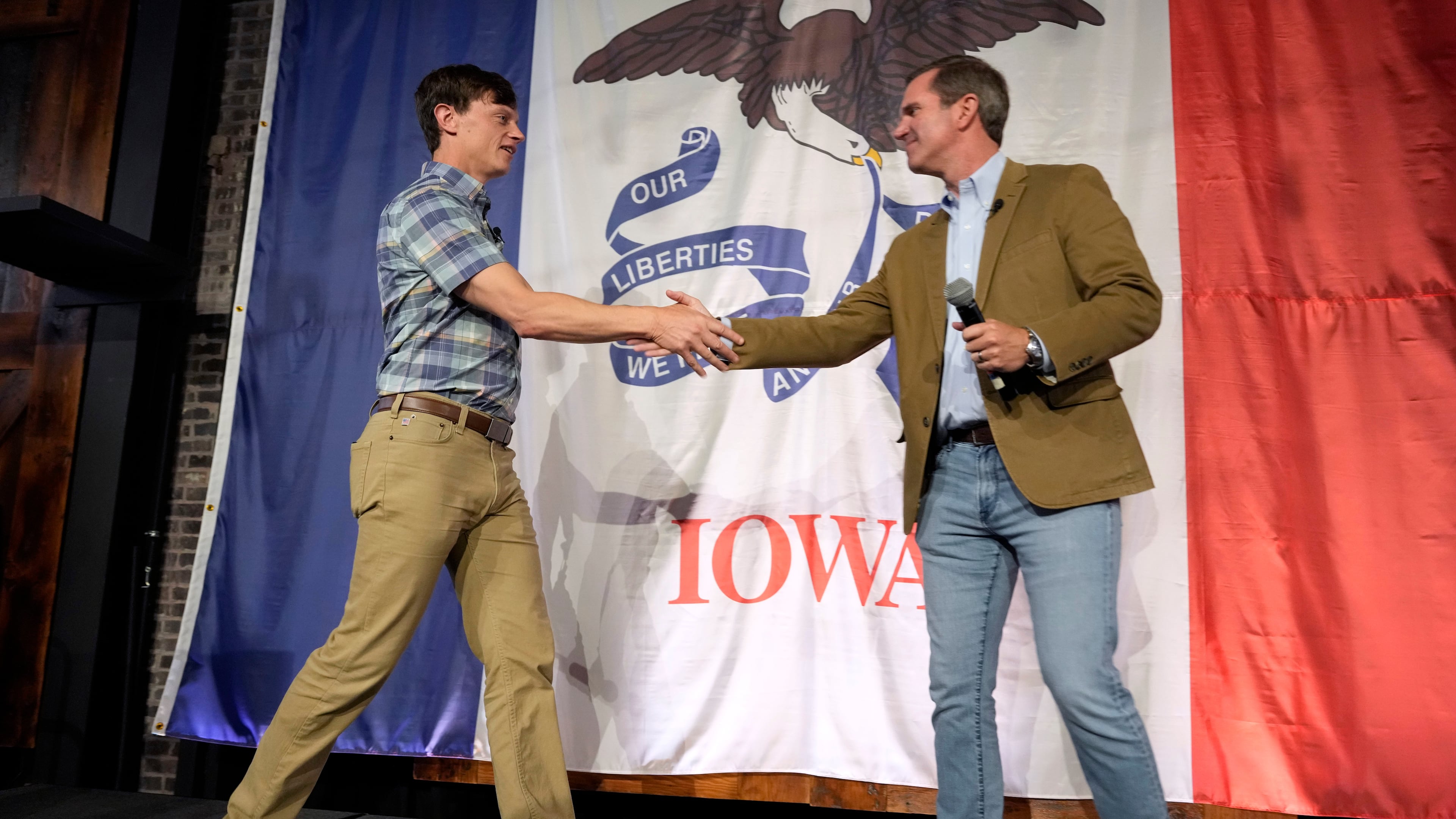 Iowa Democratic gubernatorial candidate Rob Sand, left, greets Kentucky Gov. Andy Beshear during a campaign rally, Sunday, June 7, 2026, in Des Moines, Iowa. (AP Photo/Charlie Neibergall)