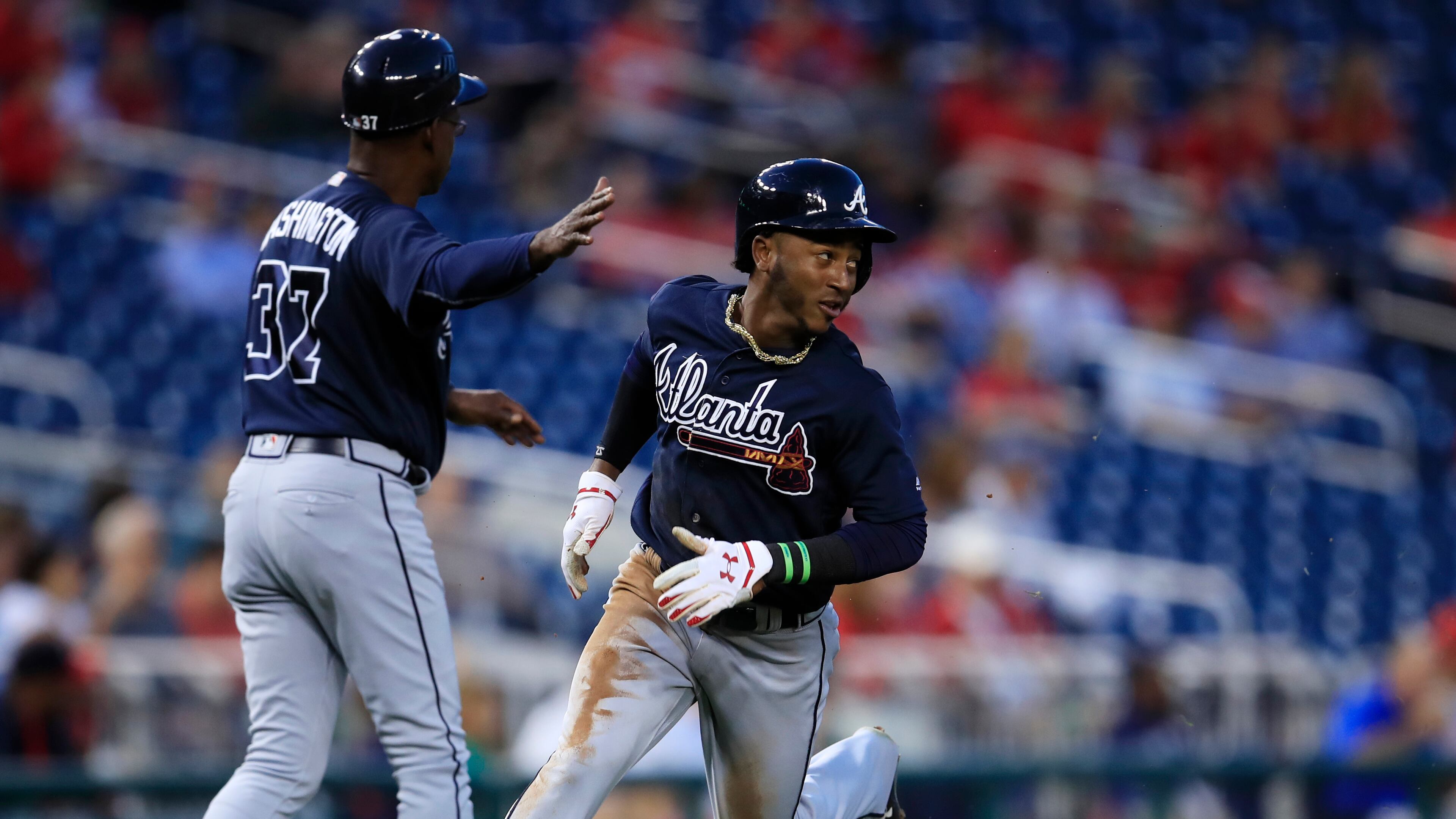 Atlanta Braves' Ozzie Albies, right, watches the ball as he runs to home plate to score during the first inning of a baseball game against the Washington Nationals in Washington, Tuesday, Sept. 12, 2017. (AP Photo/Manuel Balce Ceneta)