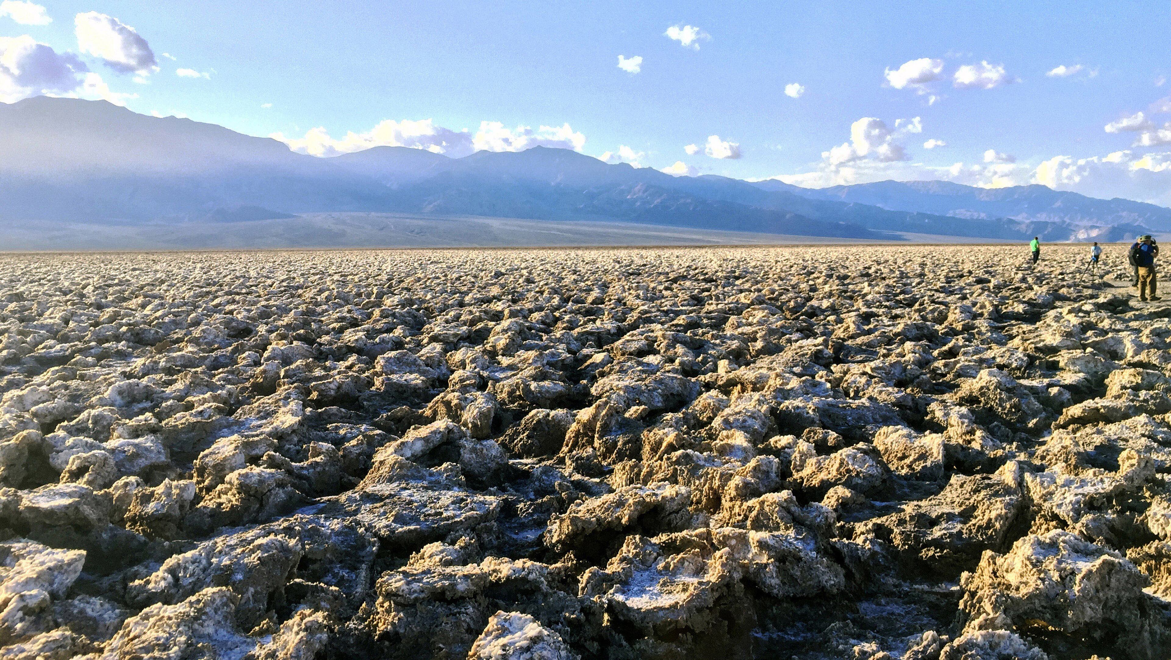 People stand in the parking lot, the only flat area amid the rugged rocky landscape of Devil’s Golf Course in Death Valley. (Lauren Williams/Orange County Register/TNS)