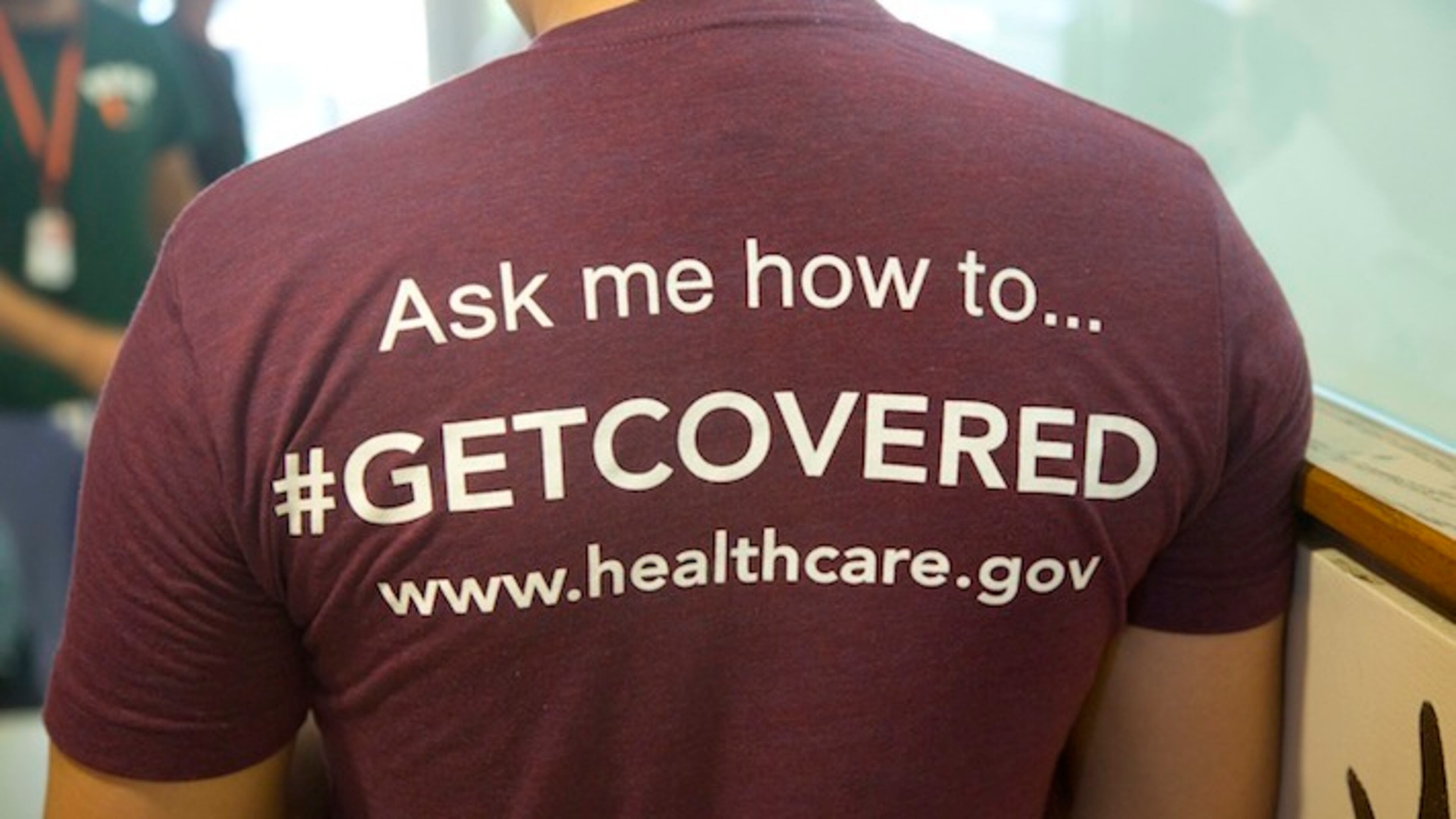 FILE - In this March 15, 2014 file photo,a volunteer health care worker wears a t-shirt, getting people to sign up for the new health care programs, in Miami. Most young Americans want any health care overhaul under President Donald Trump to look a lot like the Affordable Care Act signed into law by his predecessor, President Barack Obama. But there's one big exception: A majority of young Americans dislike "Obamacare's" requirement that all Americans buy insurance or pay a fine. (AP Photo/J Pat Carter, File)