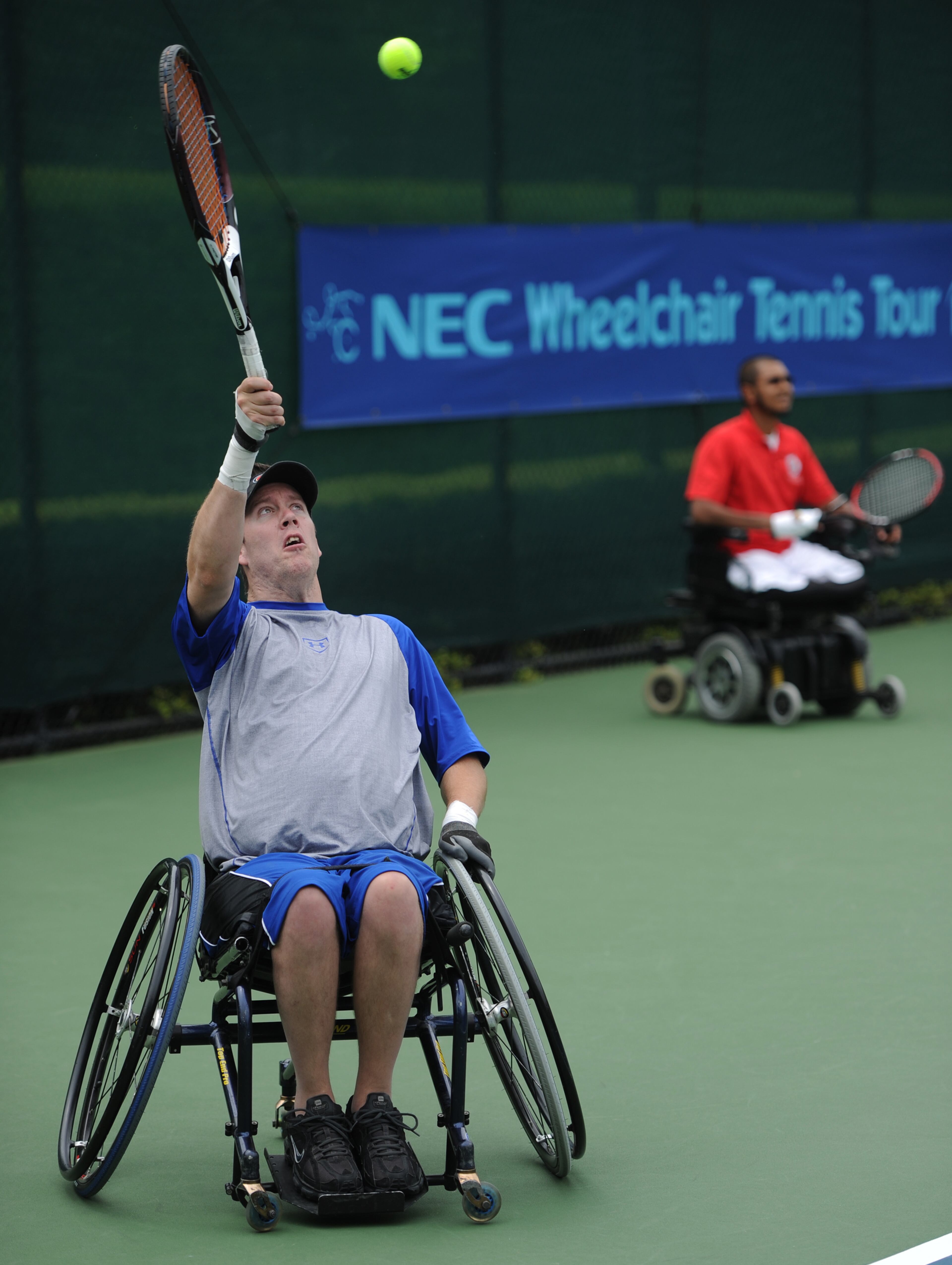 Steven Baxter,USA, serves the ball as doubles partner M. Shoeb Khan,USA,waits in the background during the Atlanta Open Wheelchair Tennis Championships at the Dunwoody Country Club on Wednesday, May 1, 2013. JOHNNY CRAWFORD / JCRAWFORD@AJC.COM