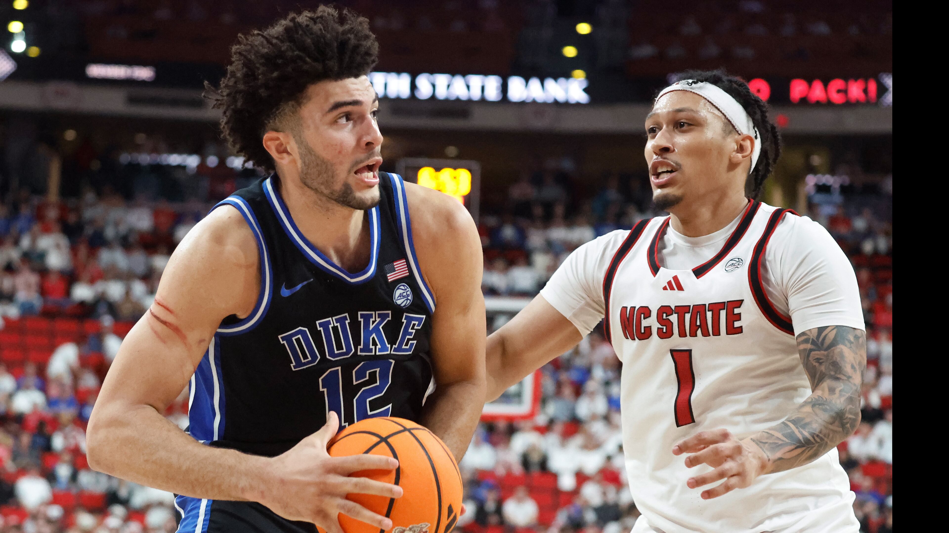Duke's Cameron Boozer (12) drives the ball past North Carolina State's Darrion Williams (1) during the second half of an NCAA college basketball game in Raleigh, N.C., Monday, March 2, 2026. (AP Photo/Karl DeBlaker)