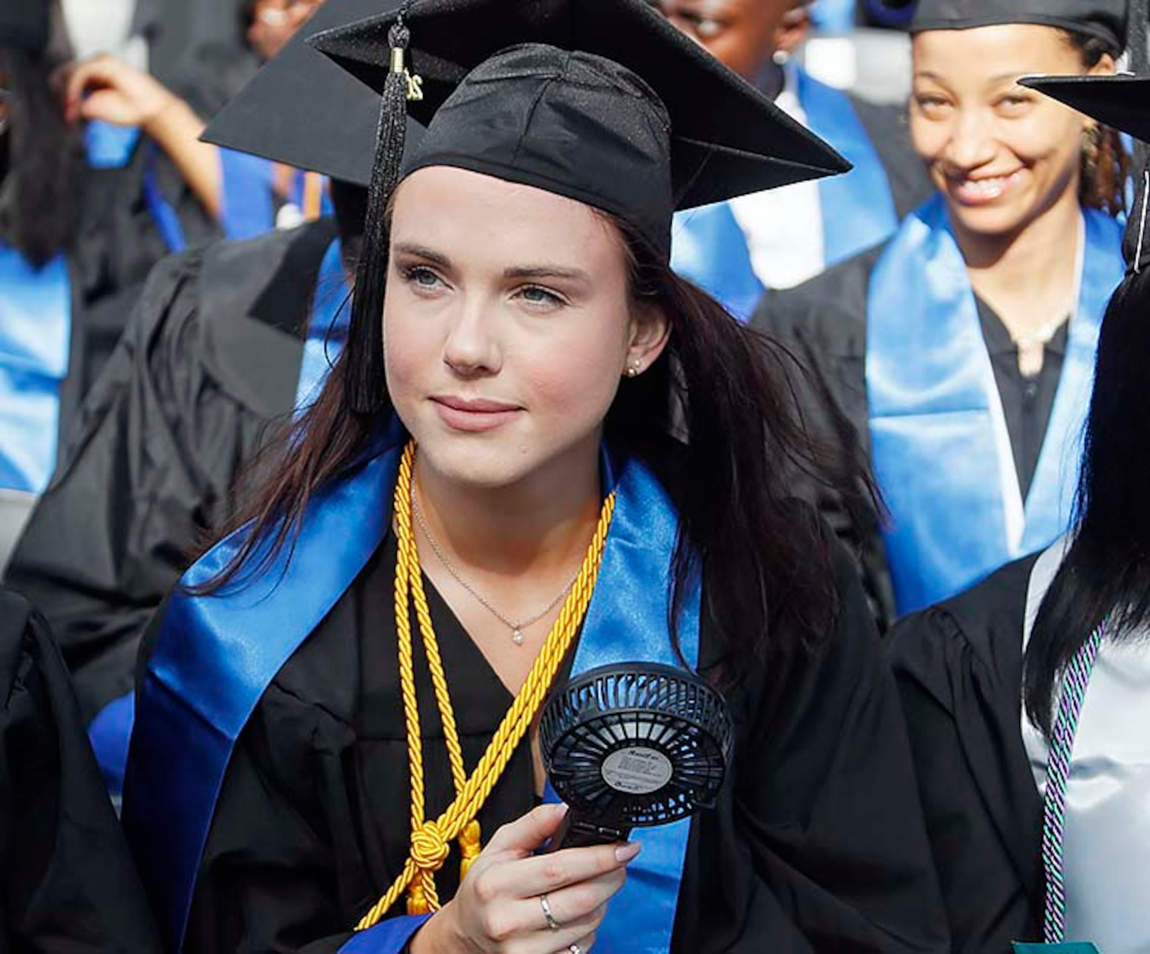 May 9, 2019 - Atlanta - Caitlyn Schussler keeps cool with a portable fan during the ceremony. Georgia State University is hosting its 104th Commencement Monday, May 6 through Tuesday, May 14 at Panther Stadium in Atlanta. Six schools held their graduation on Thursday. Bob Andres / bandres@ajc.com
