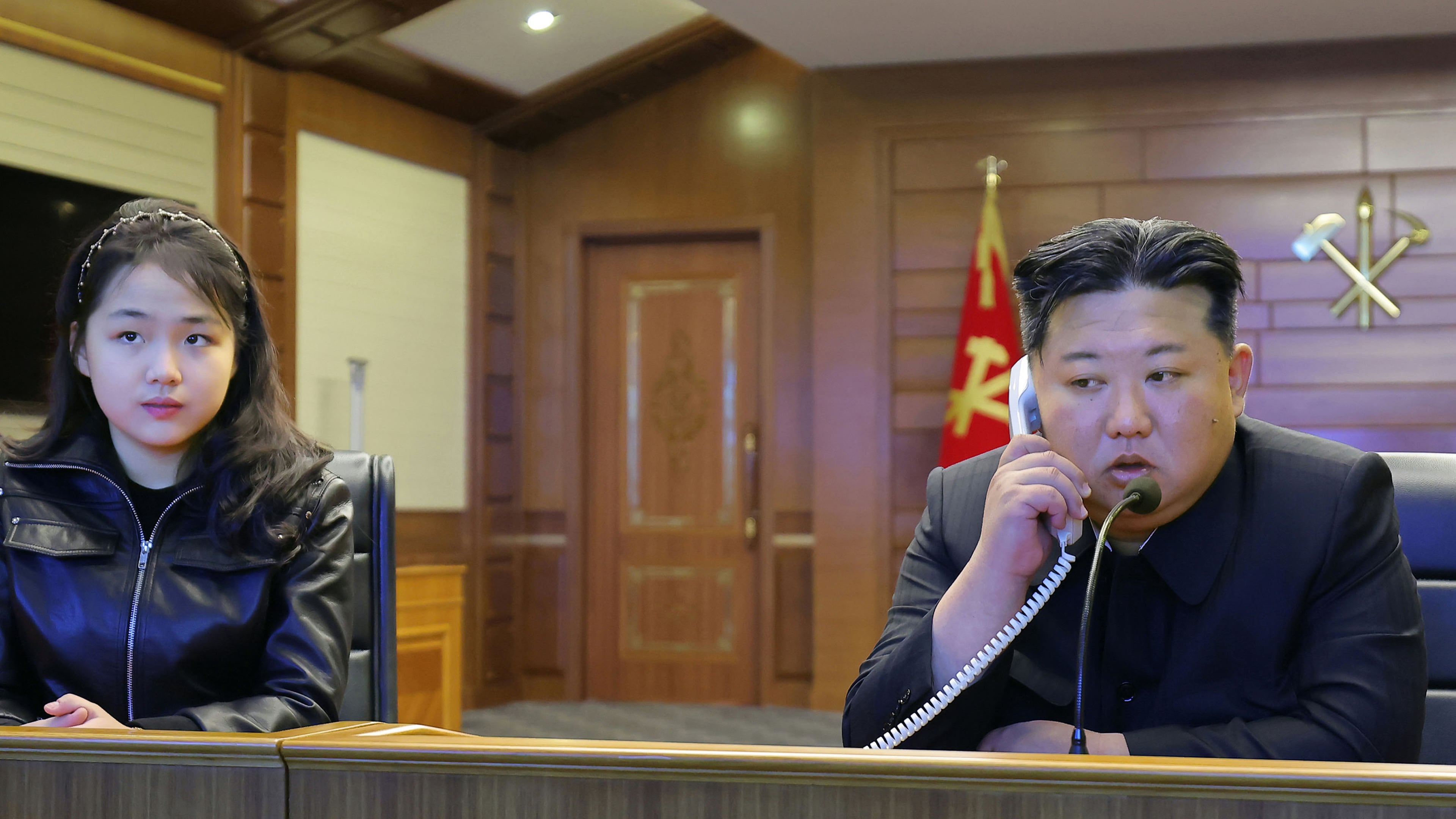 This photo provided by the North Korean government shows its leader Kim Jong Un, right, and his daughter, left, watch what it says the cruise missiles launches from the naval destroyer, the Choe Hyon, via video Tuesday, March 10, 2026, in North Korea. Independent journalists were not given access to cover the event depicted in this image distributed by the North Korean government. The content of this image is as provided and cannot be independently verified. Korean language watermark on image as provided by source reads: "KCNA" which is the abbreviation for Korean Central News Agency. (Korean Central News Agency/Korea News Service via AP)