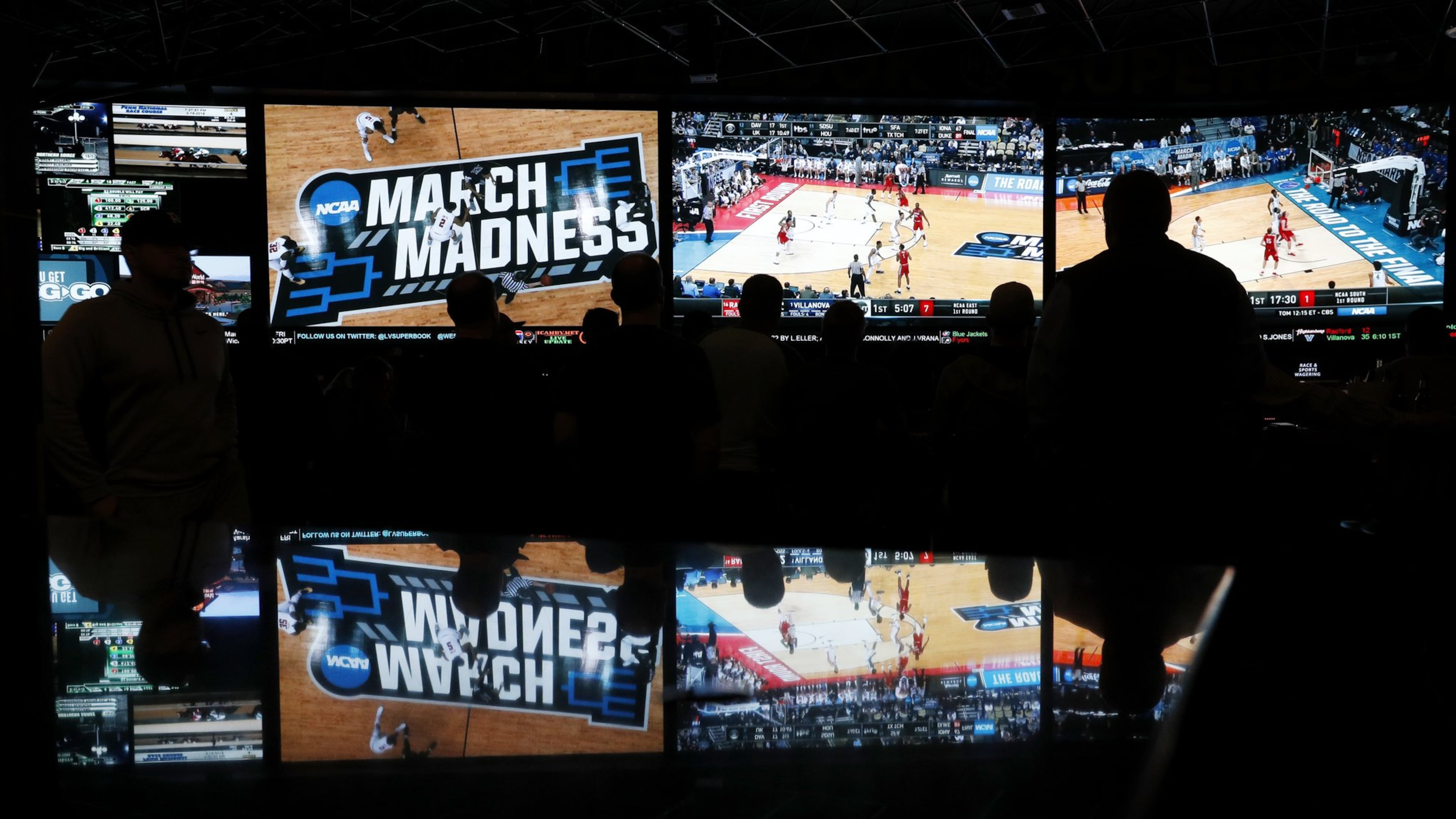 People watch coverage of the first round of the NCAA college basketball tournament at the Westgate Superbook sports book in Las Vegas. The Supreme Court has struck down a federal law that bars gambling on baseball, basketball, football and other sports in most states, giving states the go-ahead to legalize betting on sports. (AP Photo/John Locher)