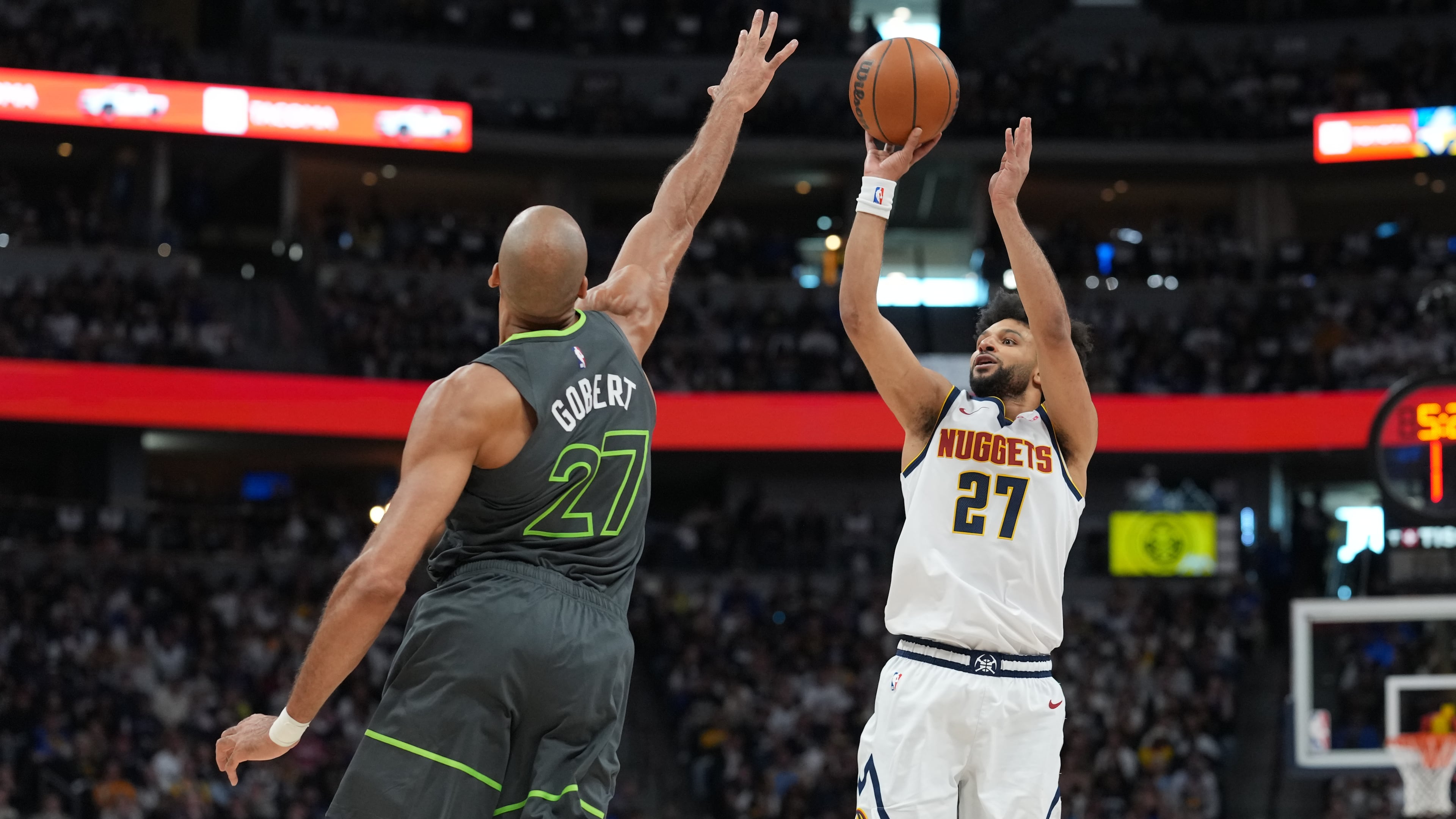 Denver Nuggets guard Jamal Murray, right, shoots over Minnesota Timberwolves center Rudy Gobert in the first half in Game 1 of a first-round NBA playoffs basketball series, Saturday, April 18, 2026, in Denver. (AP Photo/David Zalubowski)