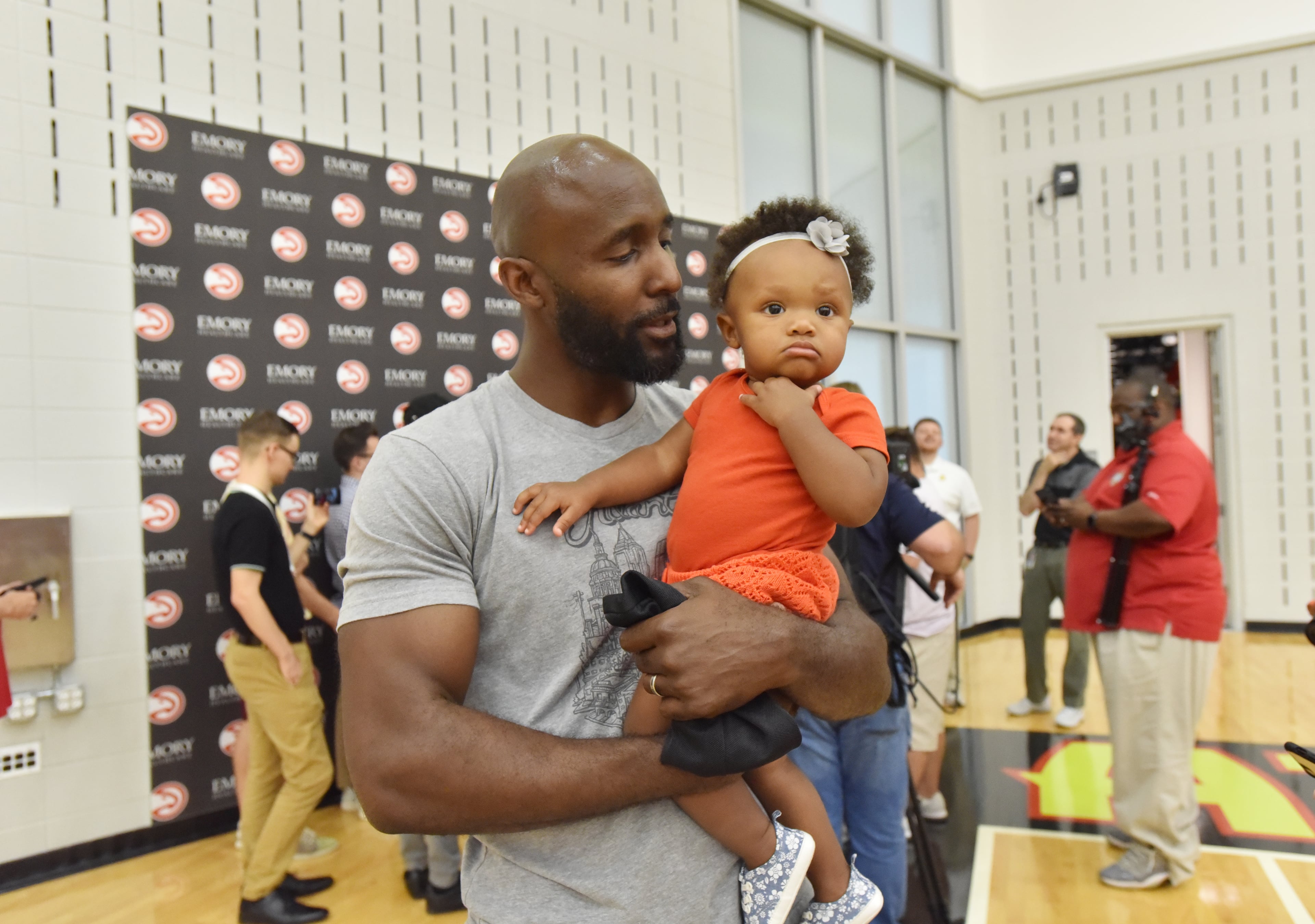 Hawks head coach Lloyd Pierce holds his daughter Maya Joy Pierce during a press conference to introduce Evan Turner. HYOSUB SHIN / HSHIN@AJC.COM