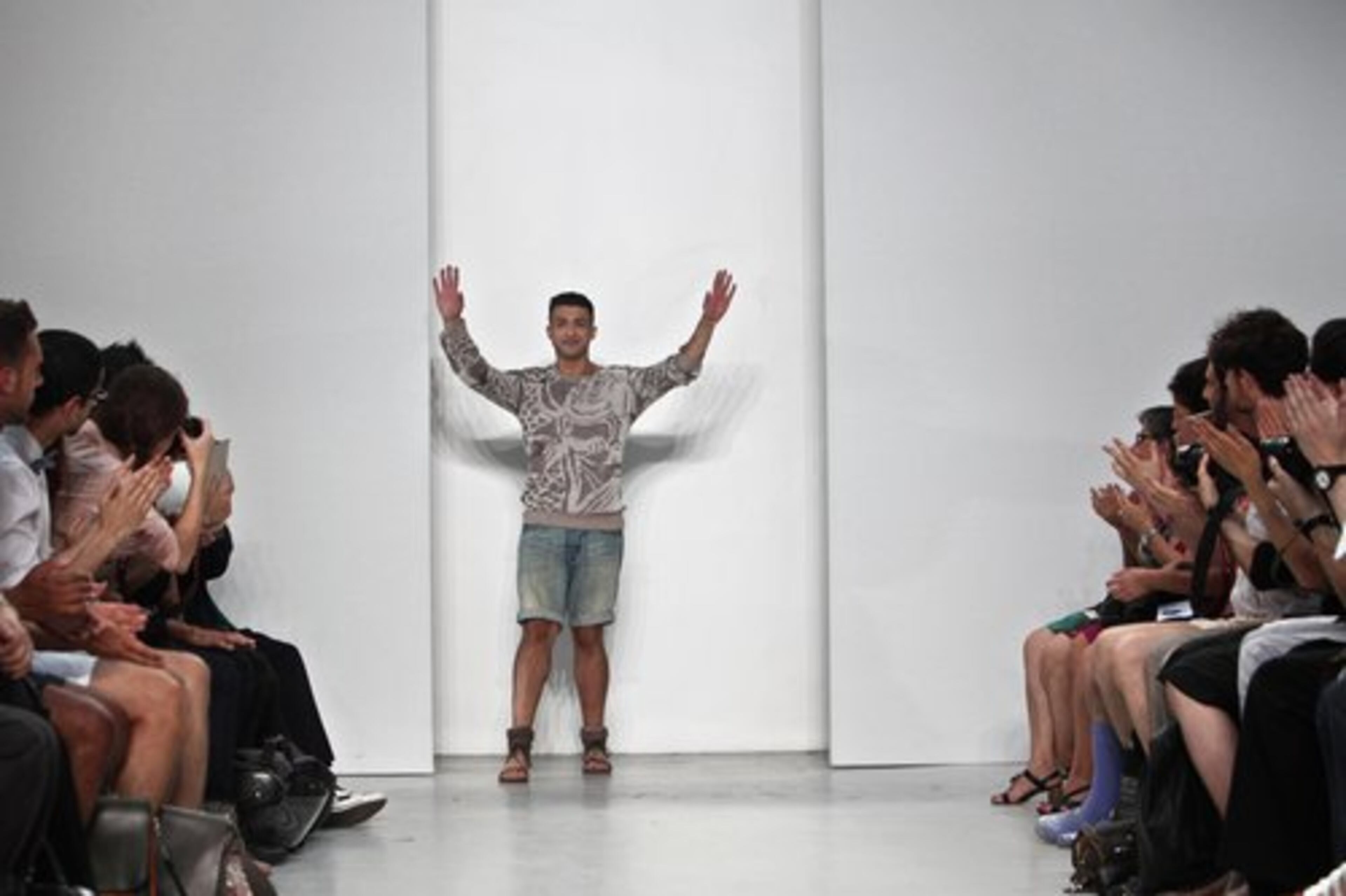 British fashion designer Qasimi acknowledges applause at the end of his Men's Spring-Summer 2011 collection in Paris.