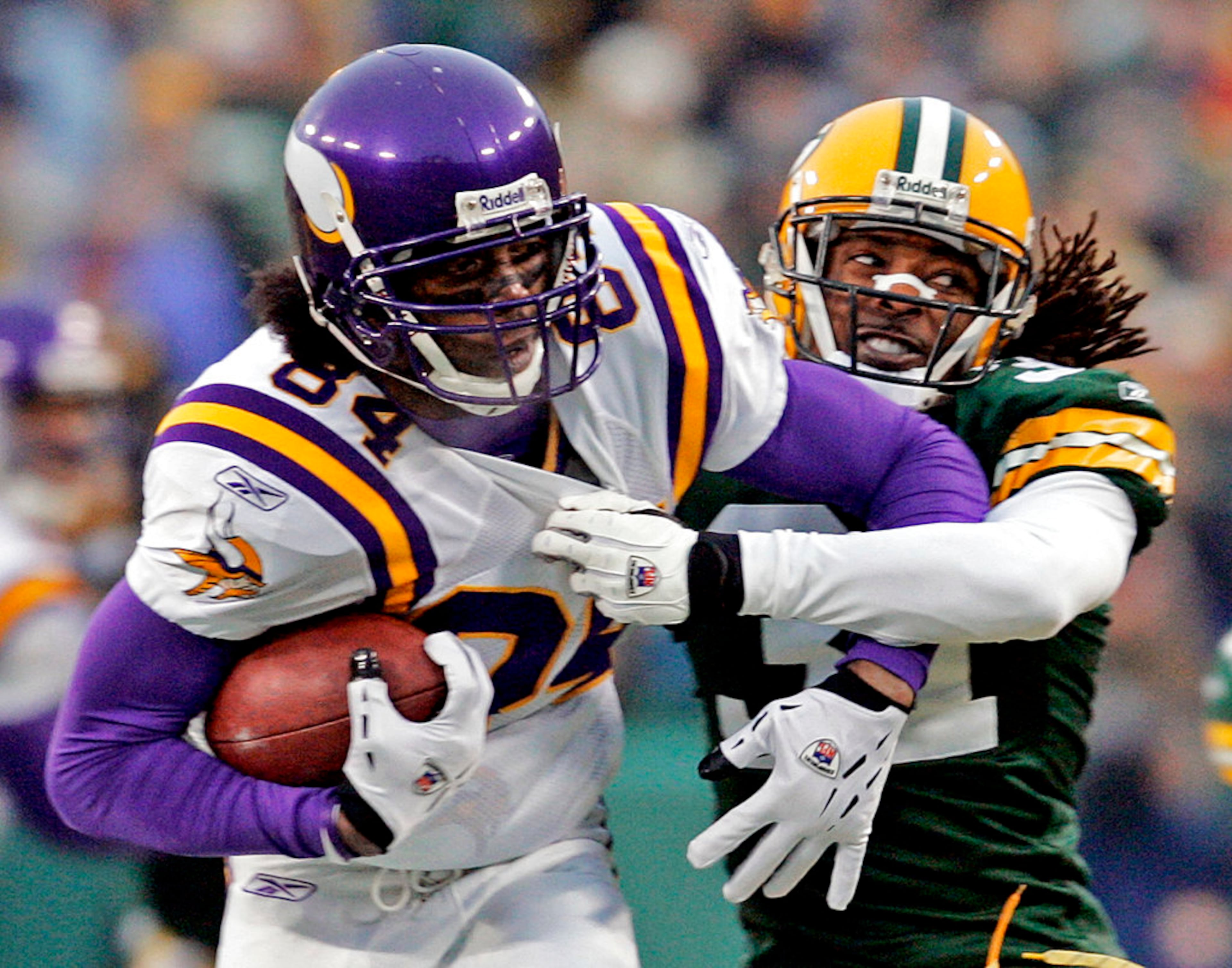 FILE - In this Jan. 9, 2005, file photo, Minnesota Vikings receiver Randy Moss (84) tries to break away from Green Bay Packers cornerback Al Harris (31) after catching a pass during the first quarter of their NFC wild-card football playoff game in Green Bay, Wis. Moss, Terrell Owens and Isaac Bruce, among others, are on the ballot in voting Saturday, Feb. 3, for the Pro Football Hall of Fame. (AP Photo/Mike Roemer, File)