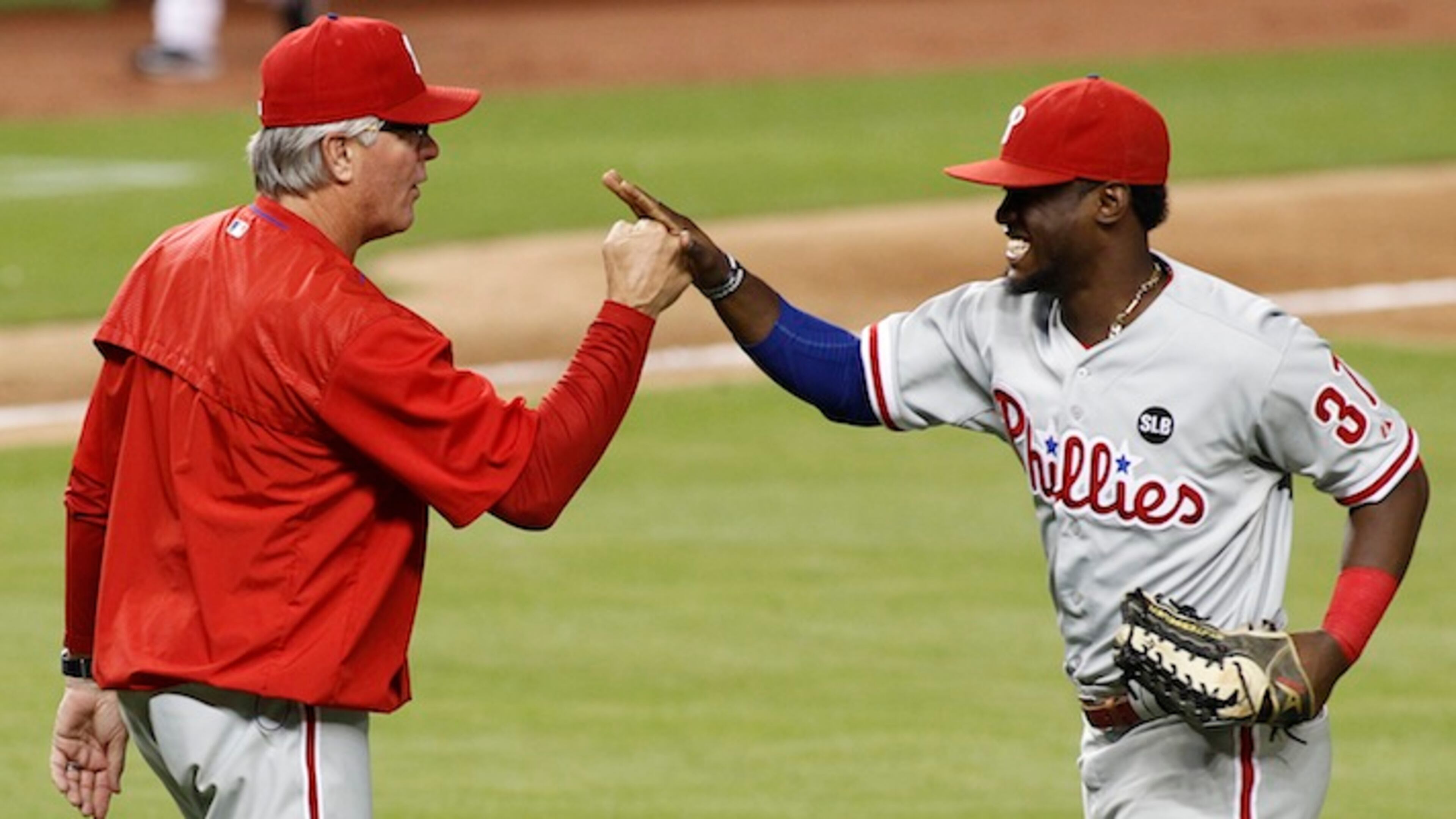Philadelphia Phillies manager Pete Mackanin, left, congratulates center fielder Odubel Herrera (37) after their team's 6-2 win over the Miami Marlins in a baseball game in Miami, Tuesday, Sept. 22, 2015. (AP Photo/Joe Skipper)