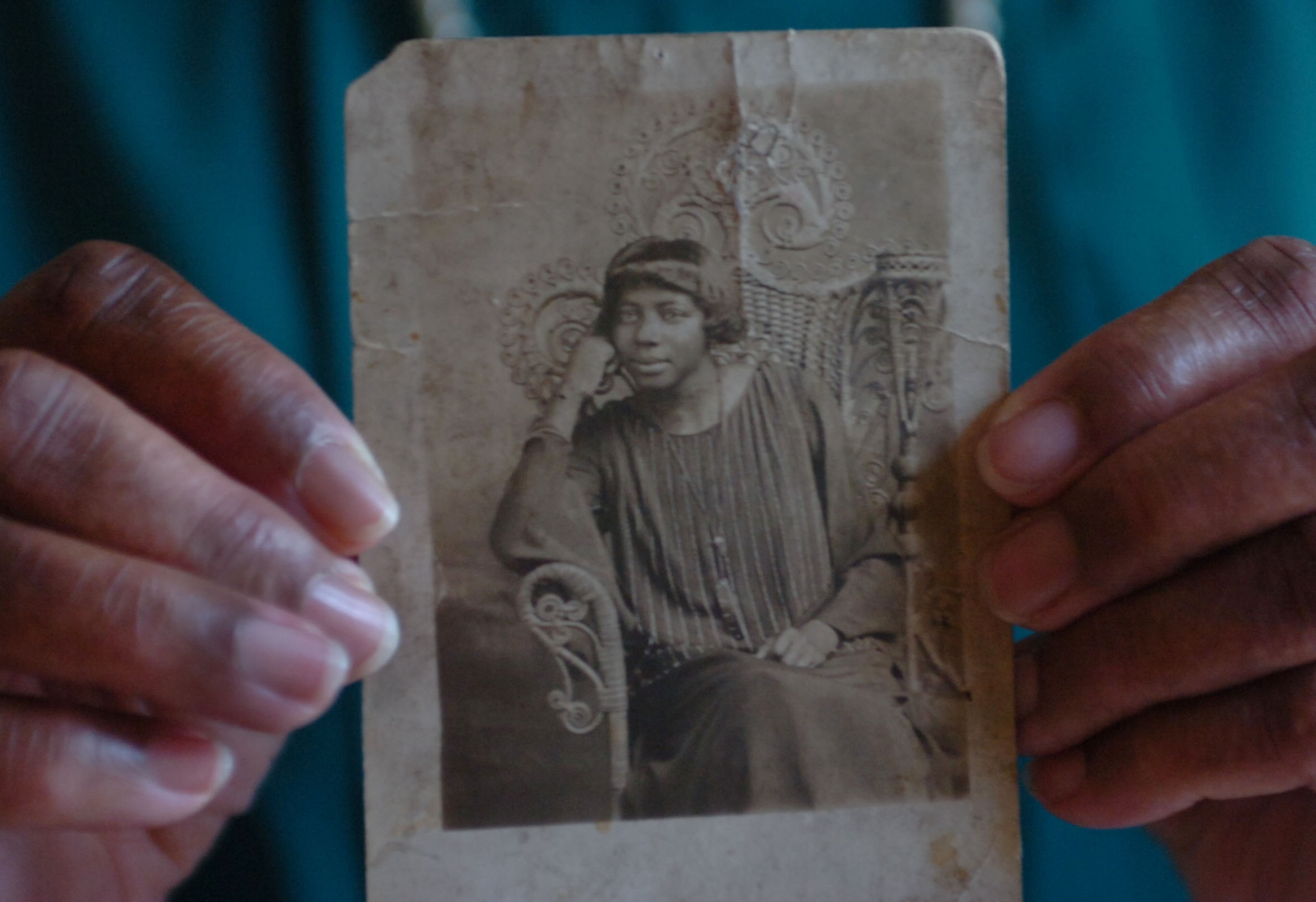Katie Bennett holds a photo of her mother, Cora Cheshier Brown. The photo dates to 1926. ANDY SHARP / AJC staff