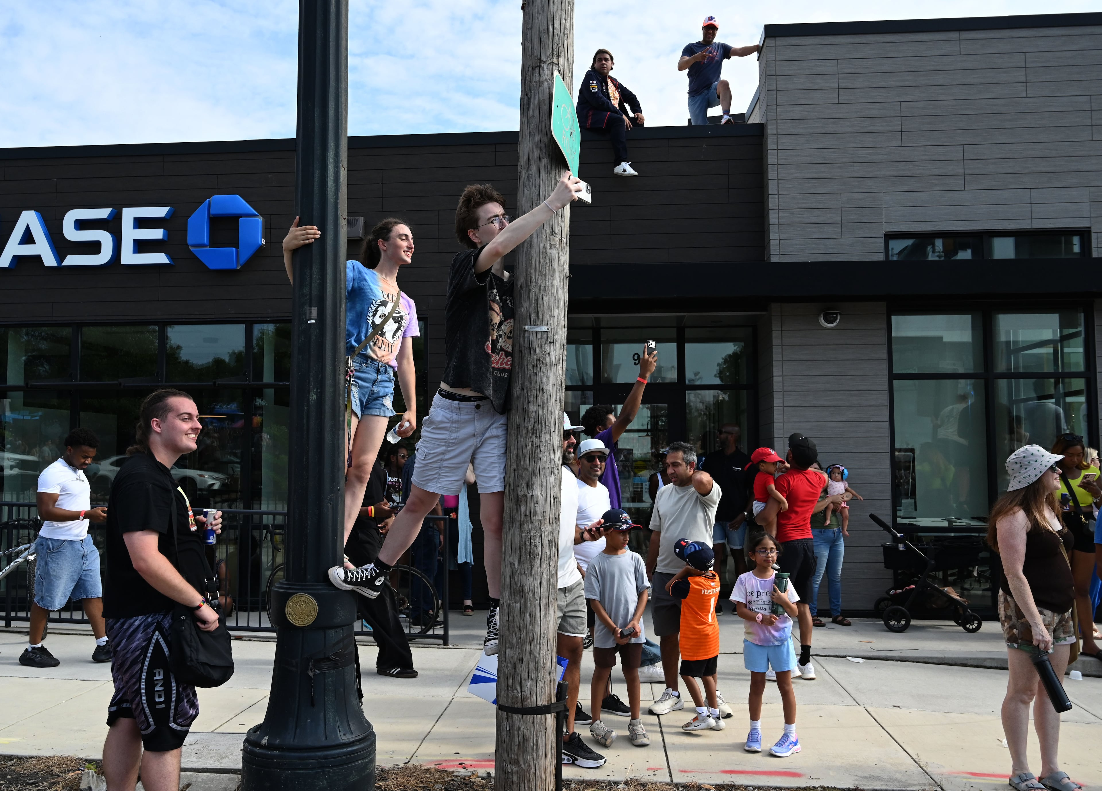 Spectators clim up in between poles to watch a demonstration run on Hank Aaron Drive during the Red Bull Showrun Atlanta Presented by Ford Racing on Saturday, Aug. 1, 2026, in Atlanta. Atlanta city officials this week approved permits for the Red Bull Showrun that will allow the live motorsports demonstration event to go on as advertised along a roughly half-mile stretch of Hank Aaron Drive — a backup location after earlier plans to hold the event near Piedmont Park ran into opposition from Midtown residents. (Hyosub Shin/AJC)
