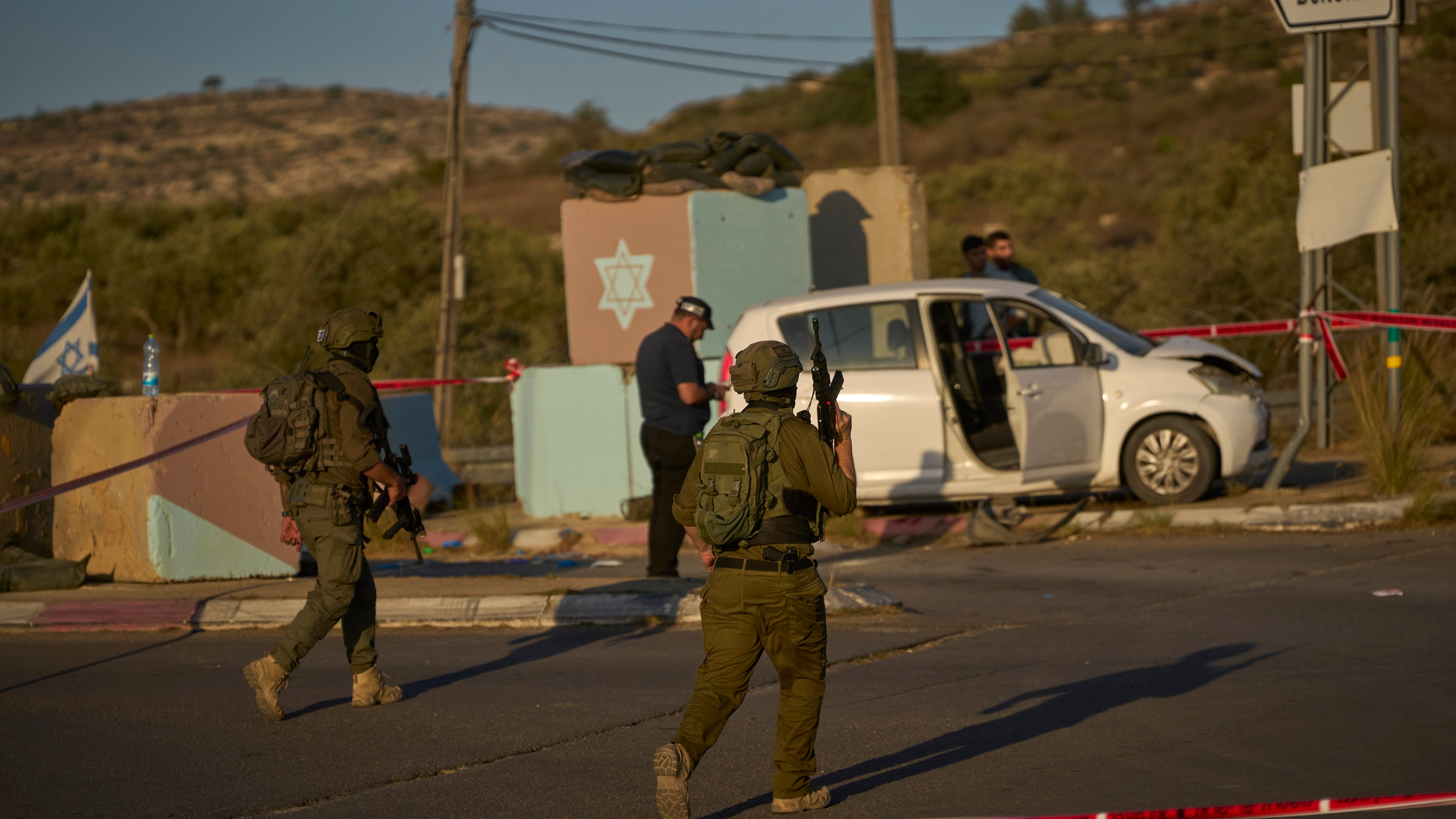 Israeli security forces inspect the scene where, according to police, a Palestinian man was shot and killed after ramming his car into a security checkpoint and seriously wounding an officer, near the West Bank Jewish settlement of Beit Horon, Wednesday, Sept. 23, 2026.(AP Photo/Ohad Zwigenberg)
