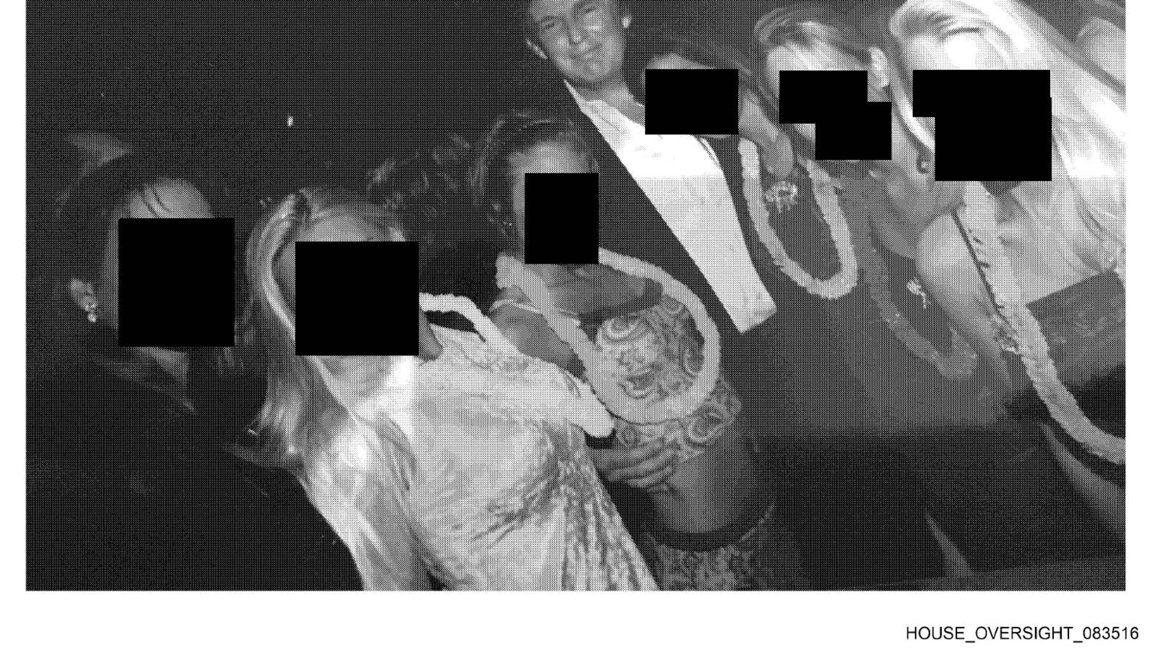 This undated, redacted photo released by Democrats on the House Oversight Committee shows Donald Trump standing with a group of women. (House Oversight Committee via AP)