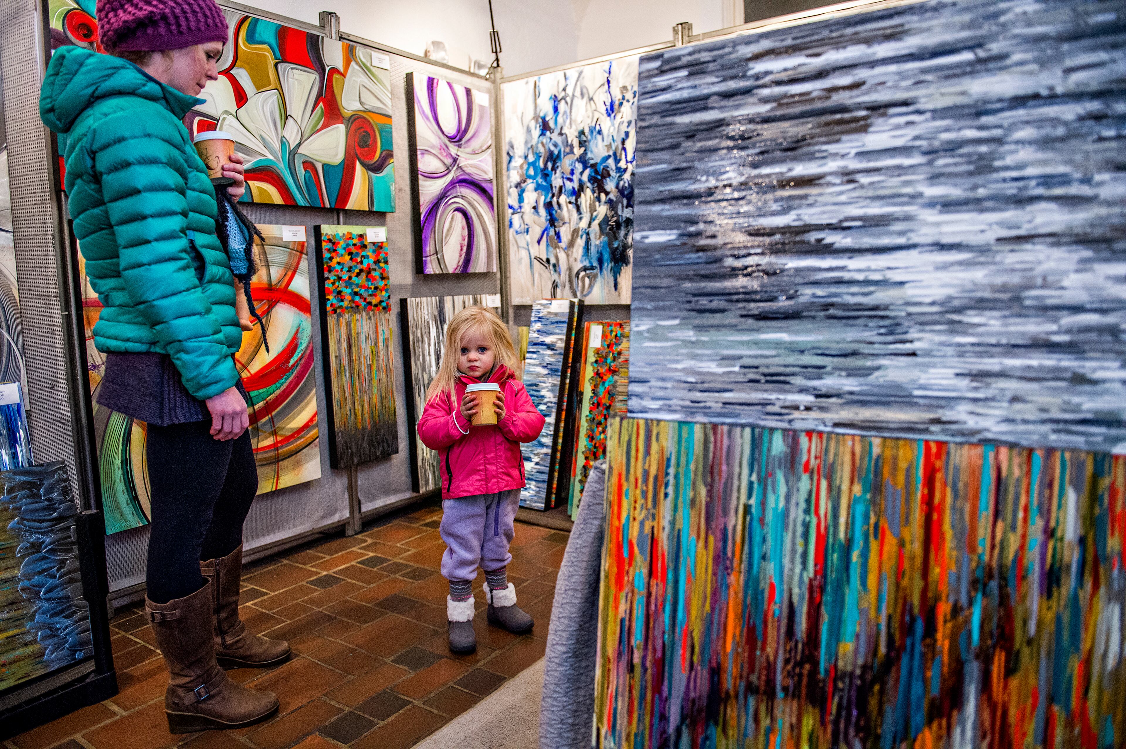 Grier James (left) and her daughter Hannah Joy look at paintings by Gina and Aaron Krawez during the Callanwolde Arts Festival in Atlanta on Saturday, January 23, 2016. The three-day festival featured numerous local and regional artists with their booths set up throughout the fine arts center. JONATHAN PHILLIPS / SPECIAL
