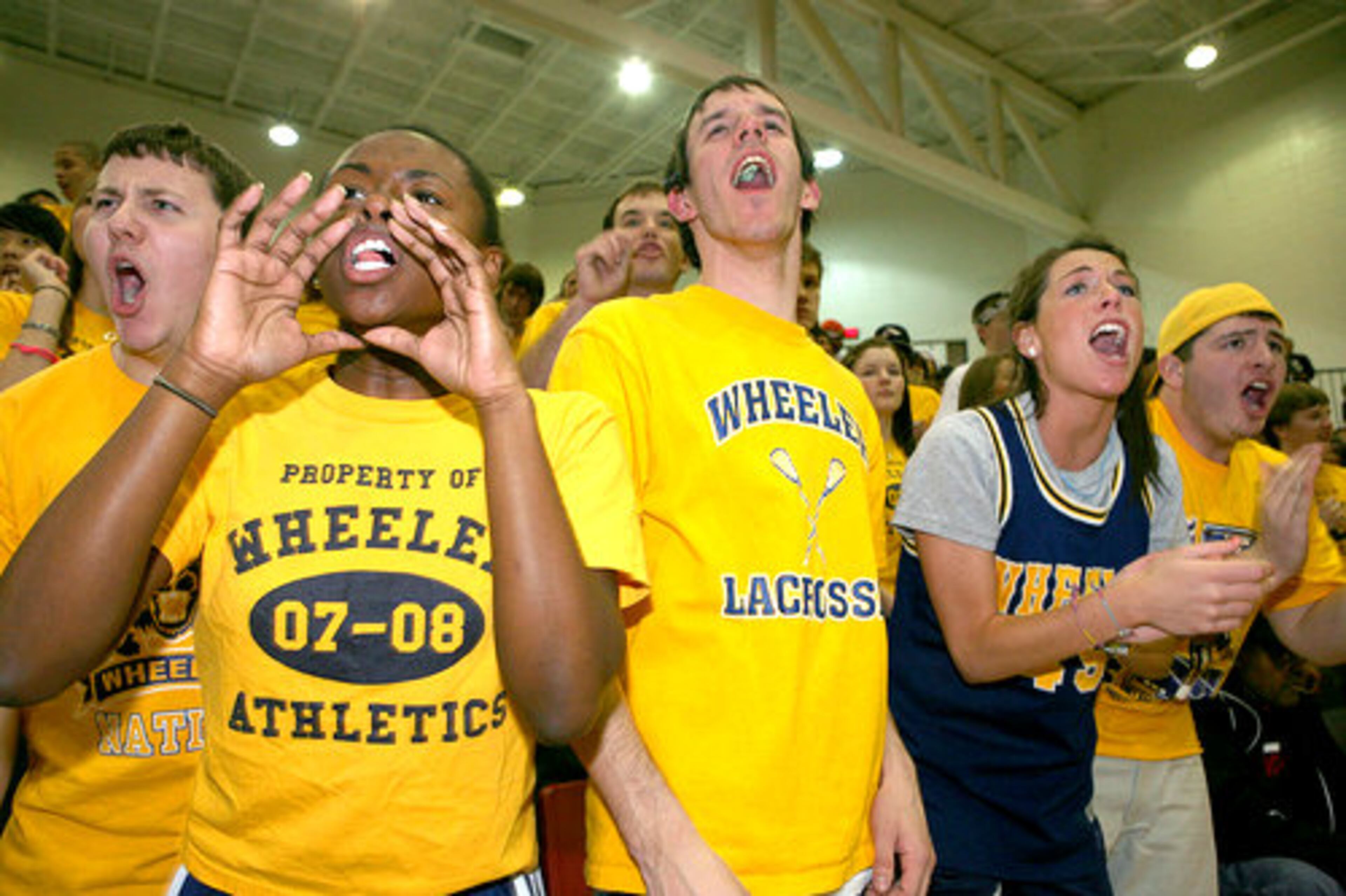 Wheeler students, (left to right) including Eric Fisher, 17, Kelly Brown, 18, John Purdue, 18, and Kendall Michaelis, 17, cheer on the Wheeler basketball team.