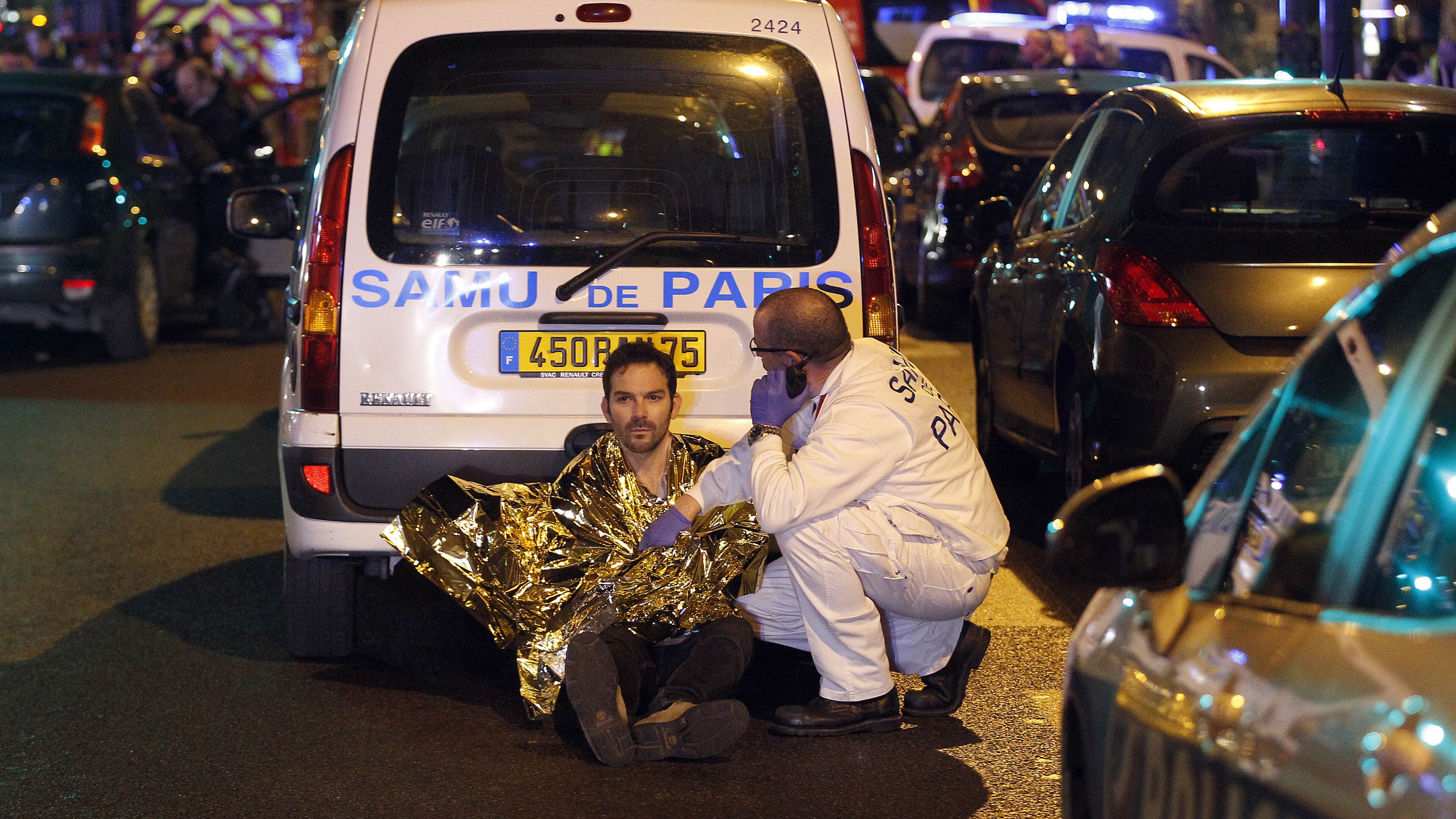 A medic tends to a man near the Boulevard des Filles-du-Calvaire after an attack November 13, 2015 in Paris, France. Gunfire and explosions in multiple locations erupted in the French capital with early casualty reports indicating at least 60 dead. (Photo by Thierry Chesnot/Getty Images)