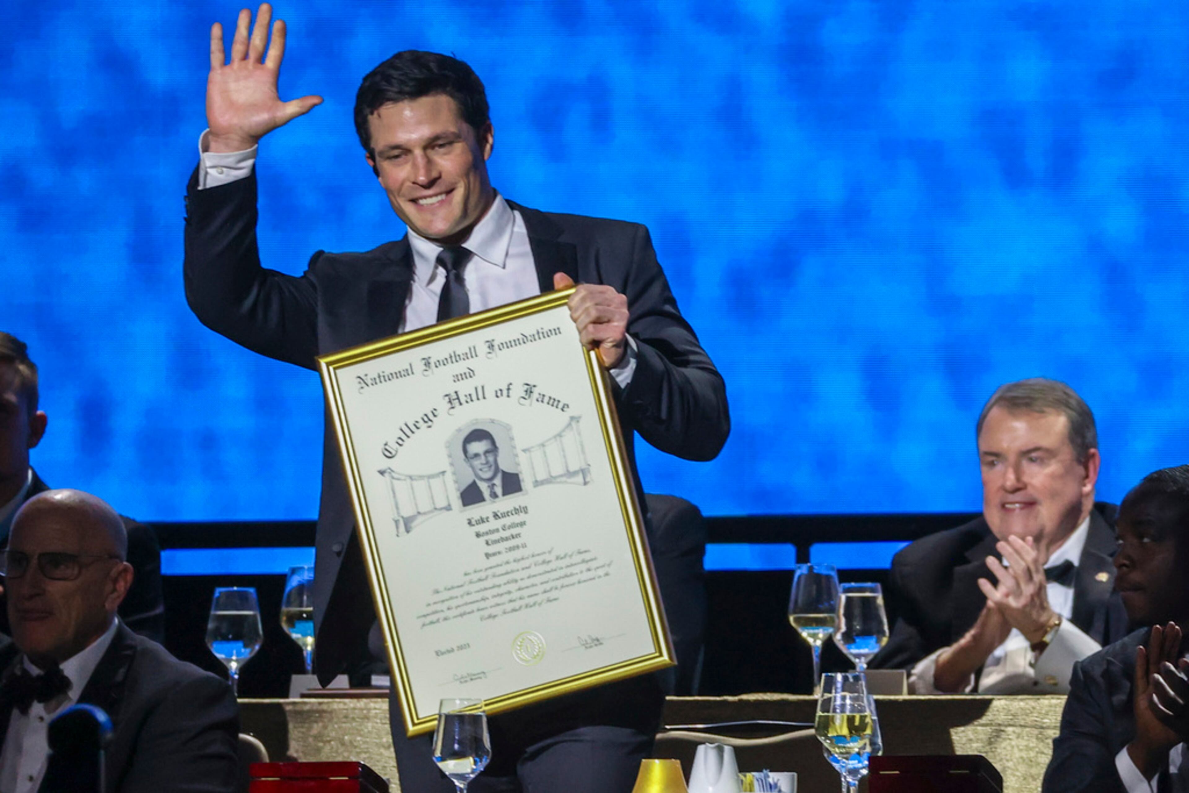 Former Boston College linebacker Luke Kuechly holds up his College Football Hall of Fame Award during the National Football Foundation Awards Dinner, Tuesday, Dec. 5, 2023, in Las Vegas. (AP Photo/Ian Maule)