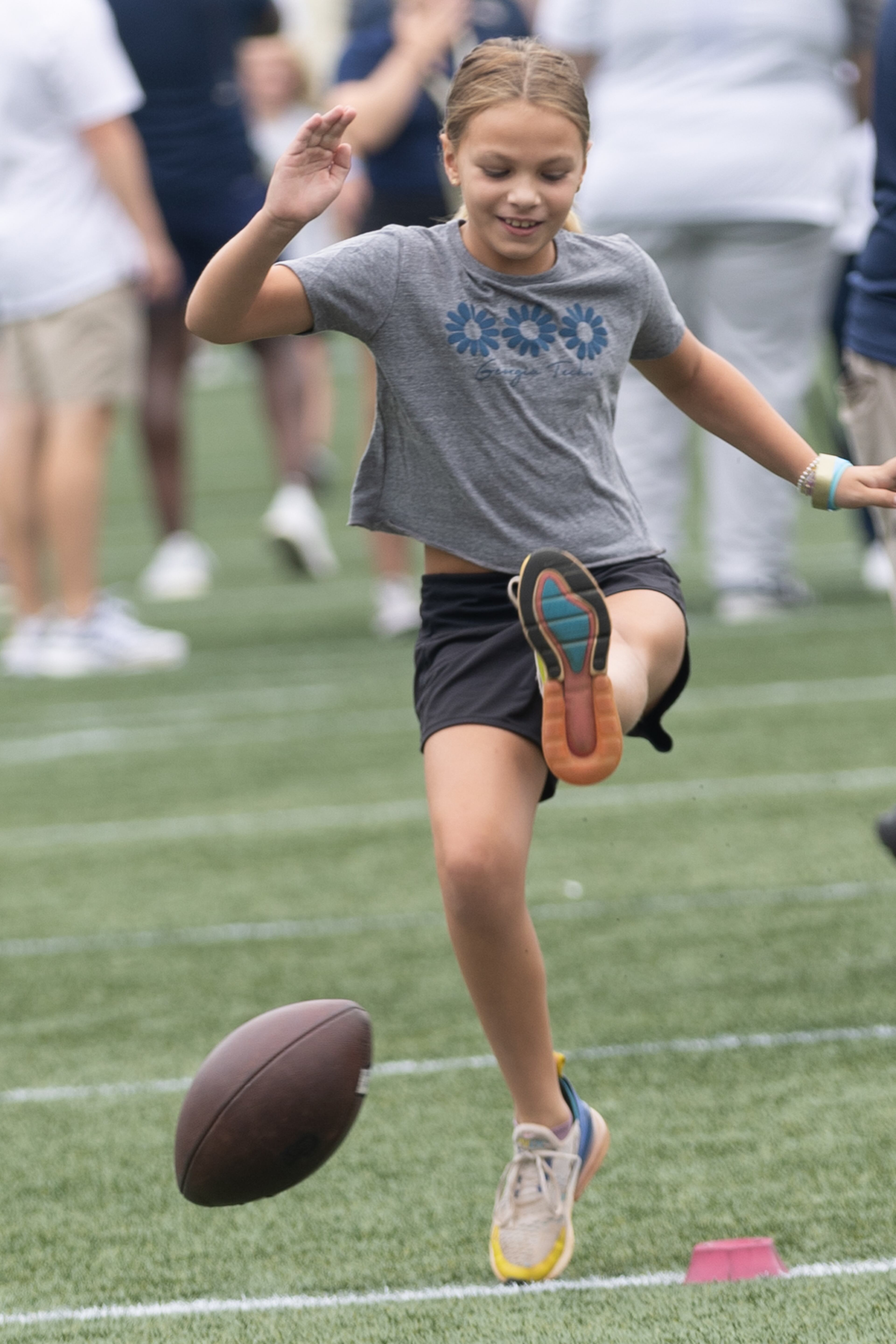 Zosia Geza, 9, tries to kick a football during Georgia Tech football’s annual First Saturday on The Flats at Bobby Dodd Stadium on July 27, 2024. (Steve Schaefer / AJC)