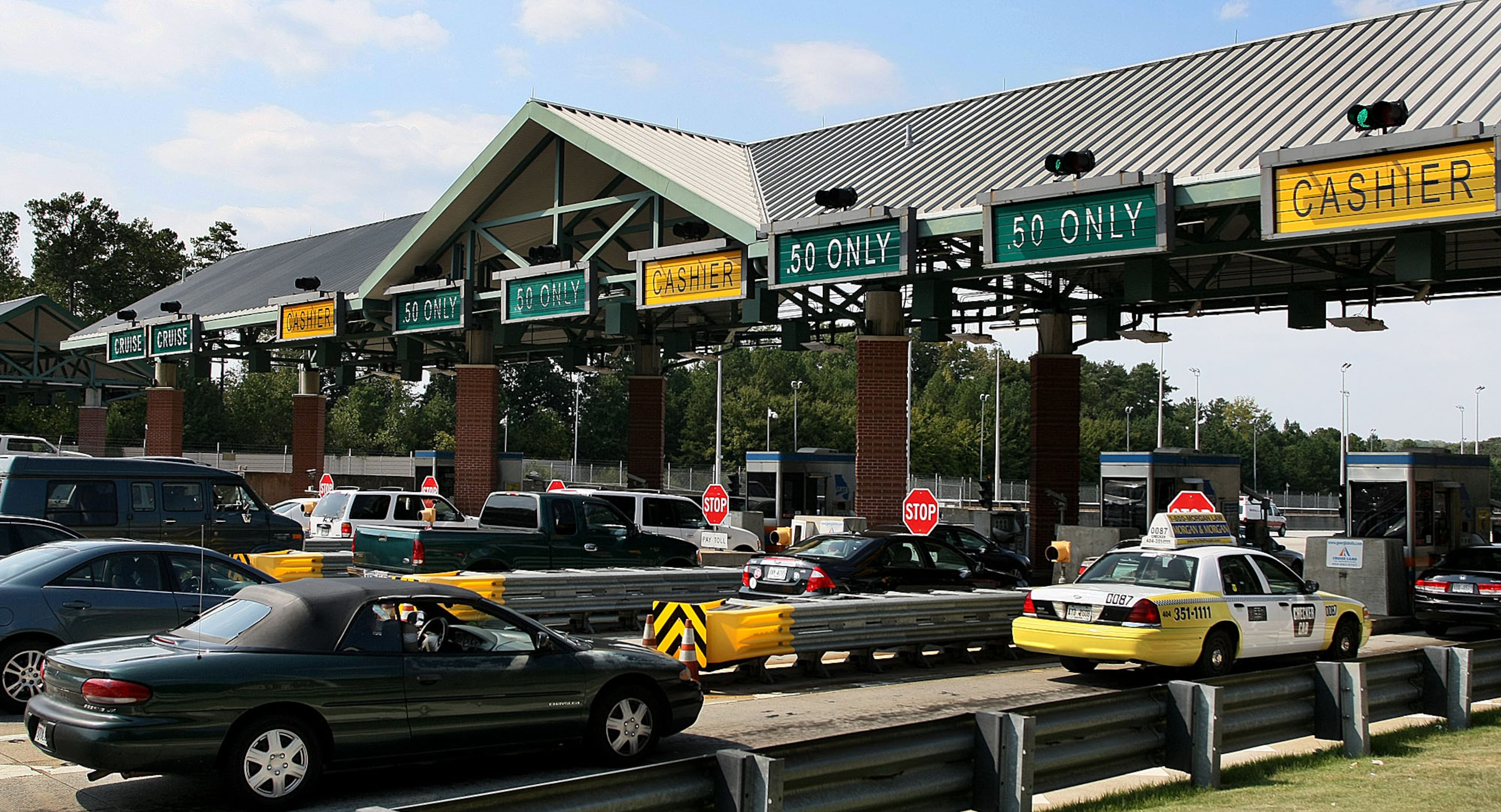 A stream of cars and trucks flow through the Georgia 400 toll booth in Buckhead on Thursday, Sept. 16th. The Georgia 400 toll, once promised to expire in 2011, is opening the door toward a longer life. Officials with direct knowledge of the plan said the State Road and Tollway Authority, chaired by Gov. Sonny Perdue, will propose to leave the tolls on, in exchange for a handful of projects along the corridor including completing the interchange at Ga. 400 and I-85. Sam Massell, a Ga. 400 advocate who 20 years ago promised the toll would come down, said he could stomach leaving them on in exchange for that project. Phil Skinner pskinner@ajc.com