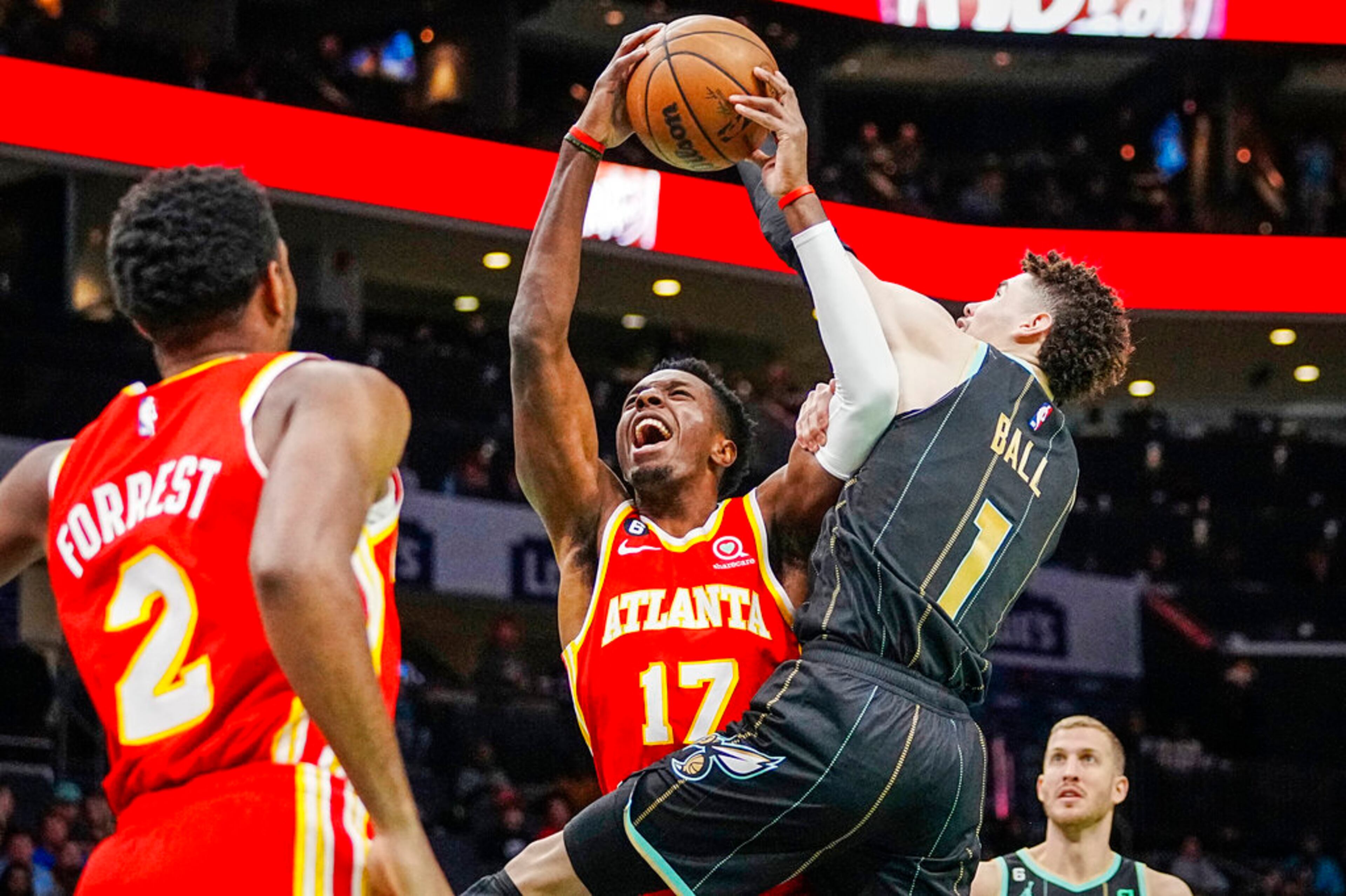 Atlanta Hawks forward Onyeka Okongwu (17) drives into the defense of Charlotte Hornets guard LaMelo Ball (1) during the first half of an NBA basketball game Friday, Dec. 16, 2022, in Charlotte, N.C. (AP Photo/Rusty Jones)