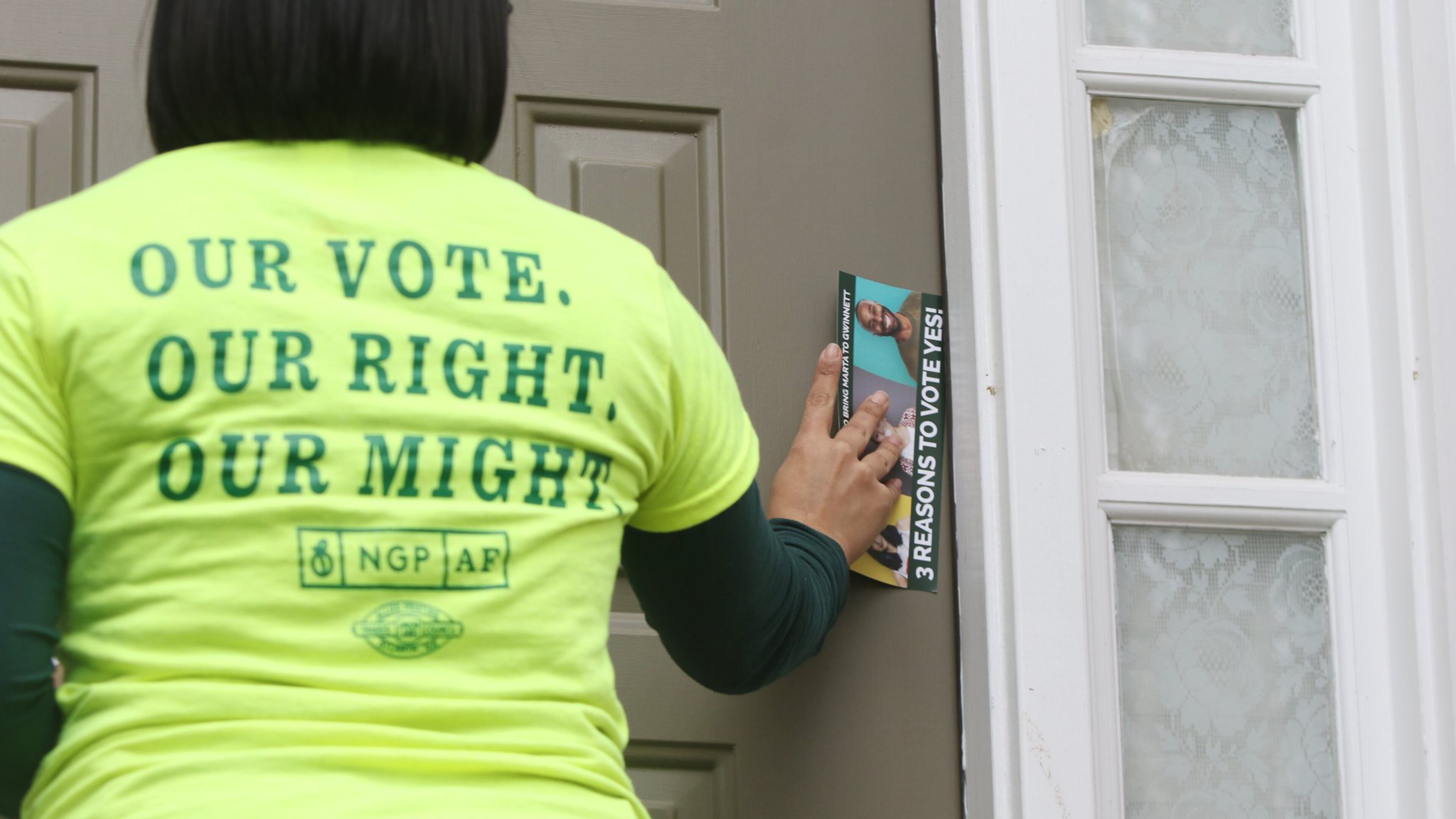 A worker with the New Georgia Project Action Fund leaves information at a home in Norcross in 2019. (AJC file photo)