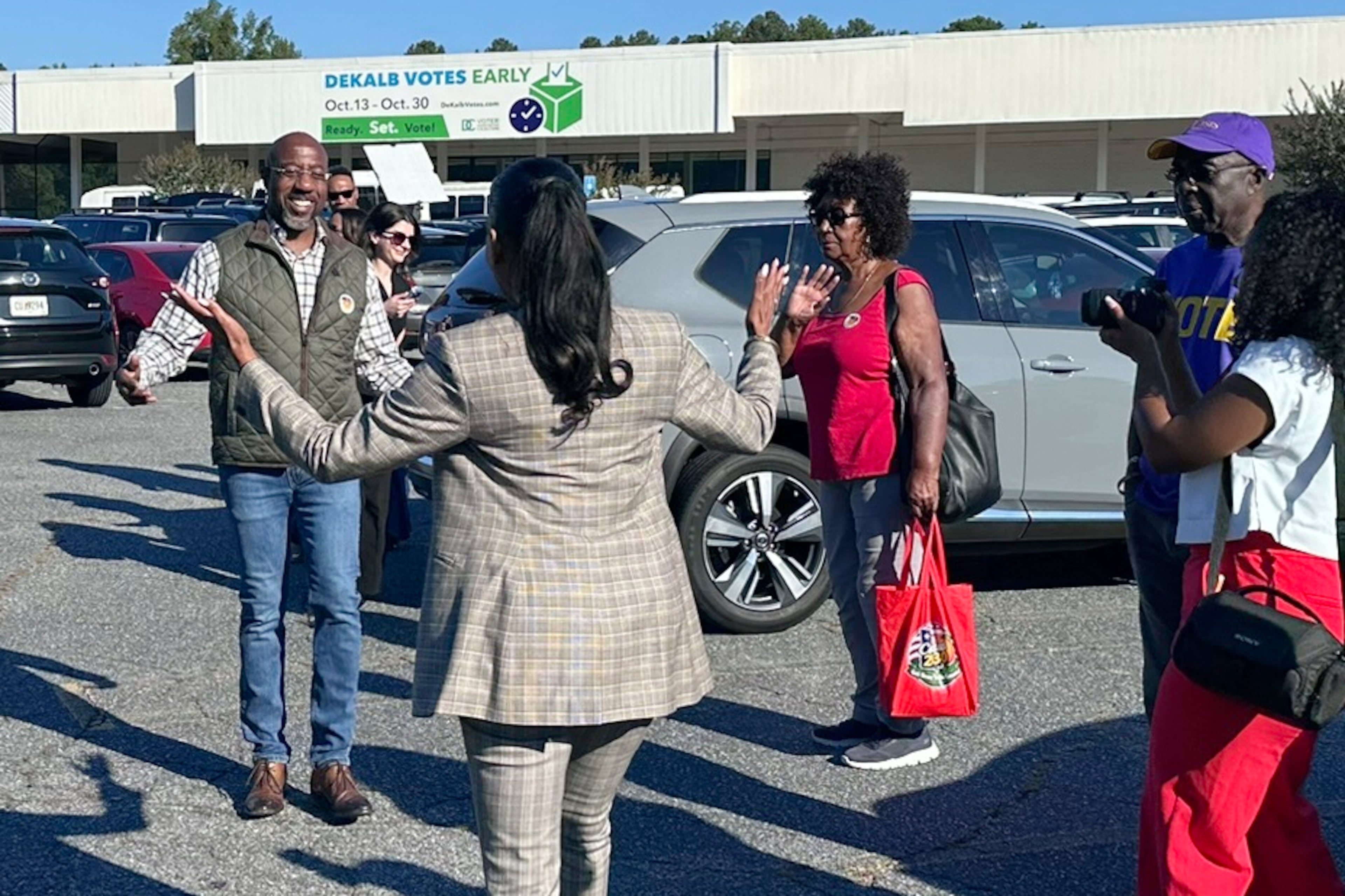 Keisha Lance Bottoms, Democratic nominee for Georgia governor, greets U.S. Sen. Raphael Warnock outside a polling place after the senator cast his ballot on the first day of early voting on Tuesday in Decatur. (Bill Barrow/AP)