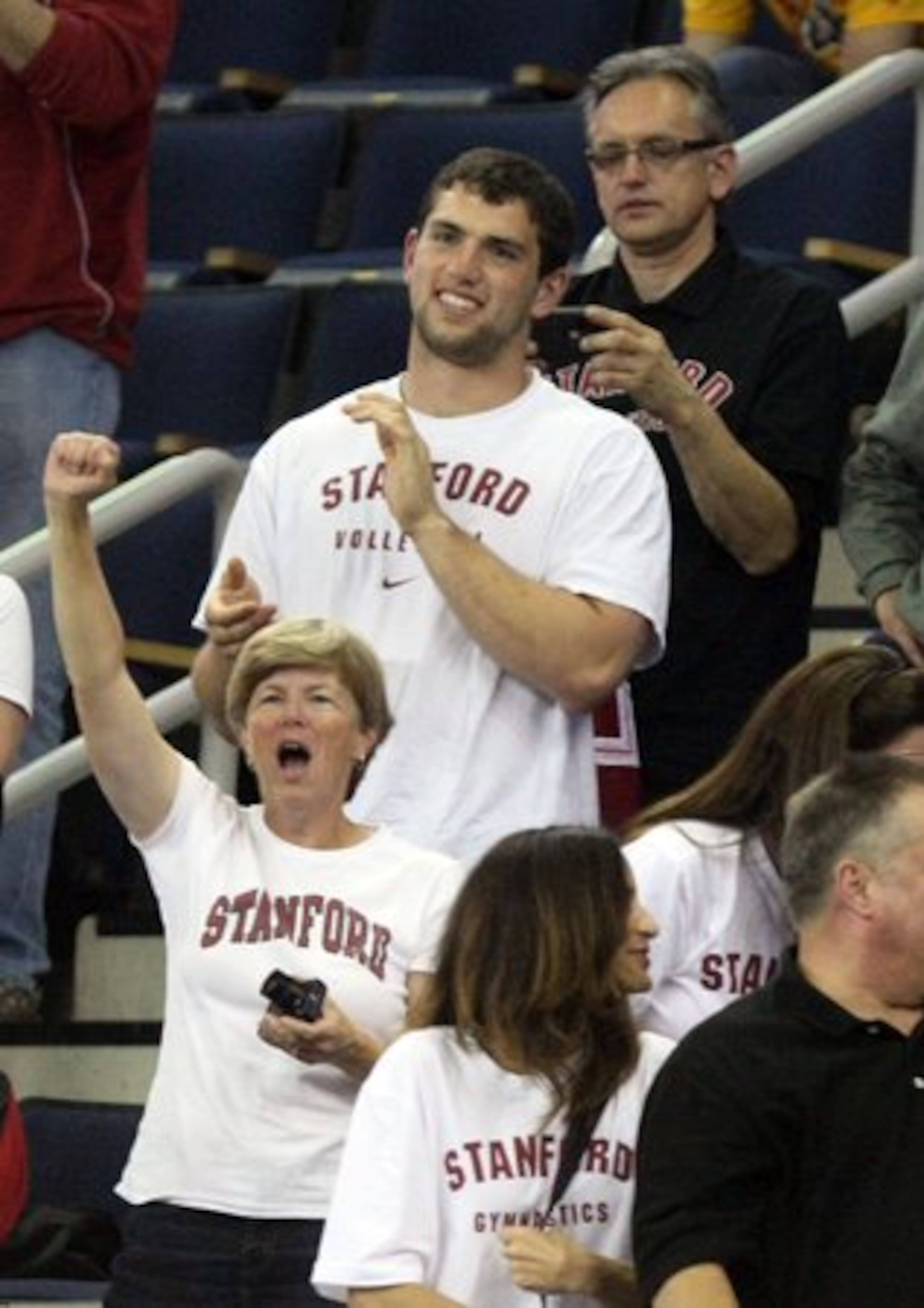Former Stanford quarterback Andrew Luck, top, cheers with Stanford fans after the Stanford Gymnastics team finished fourth in the NCAA Gymnastics Super Six finals at the Arena at the Gwinnett Center in Duluth Saturday, April 21, 2012.