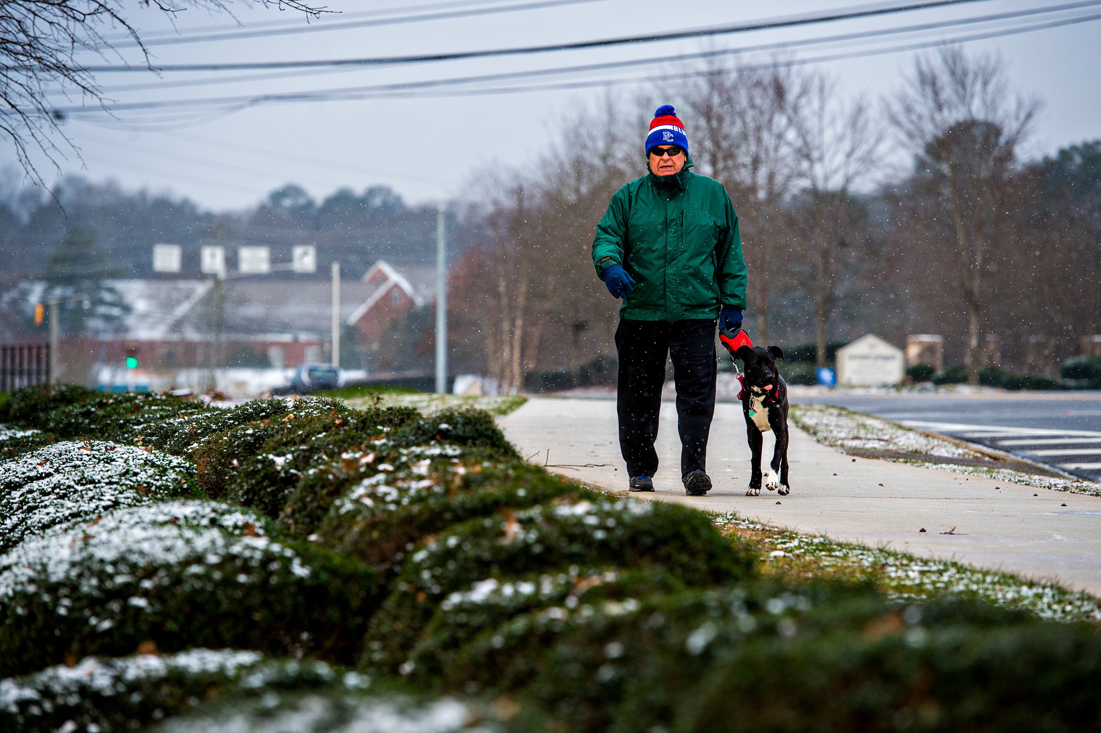 Larry Sinkuler walks his dog Jezzabelle down Nesbit Ferry Road in Alpharetta as snow falls around her on Saturday, January 23, 2016. JONATHAN PHILLIPS / SPECIAL