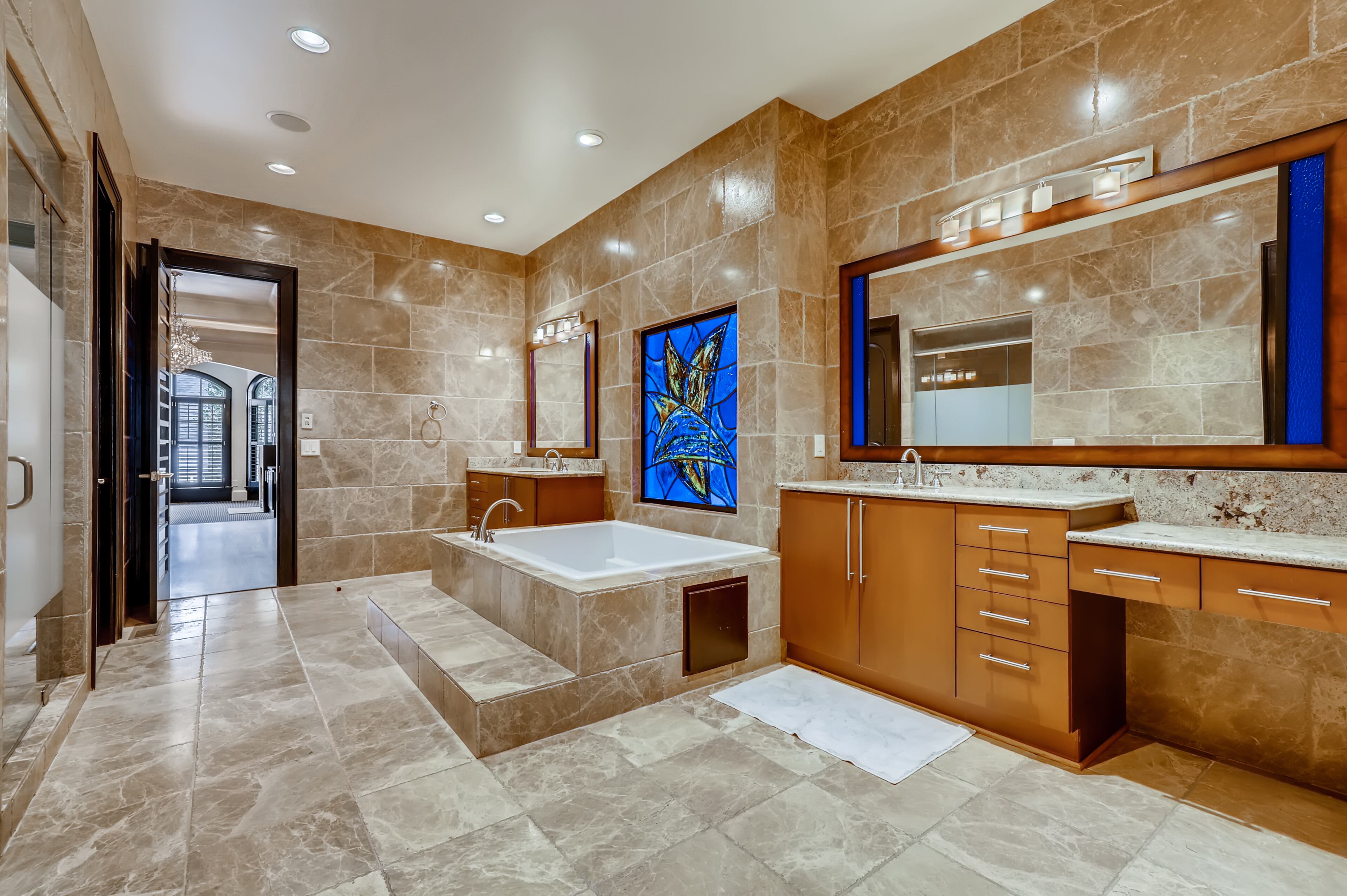 Luxurious master bath with stone floors and countertops. Text by Diane Arnold