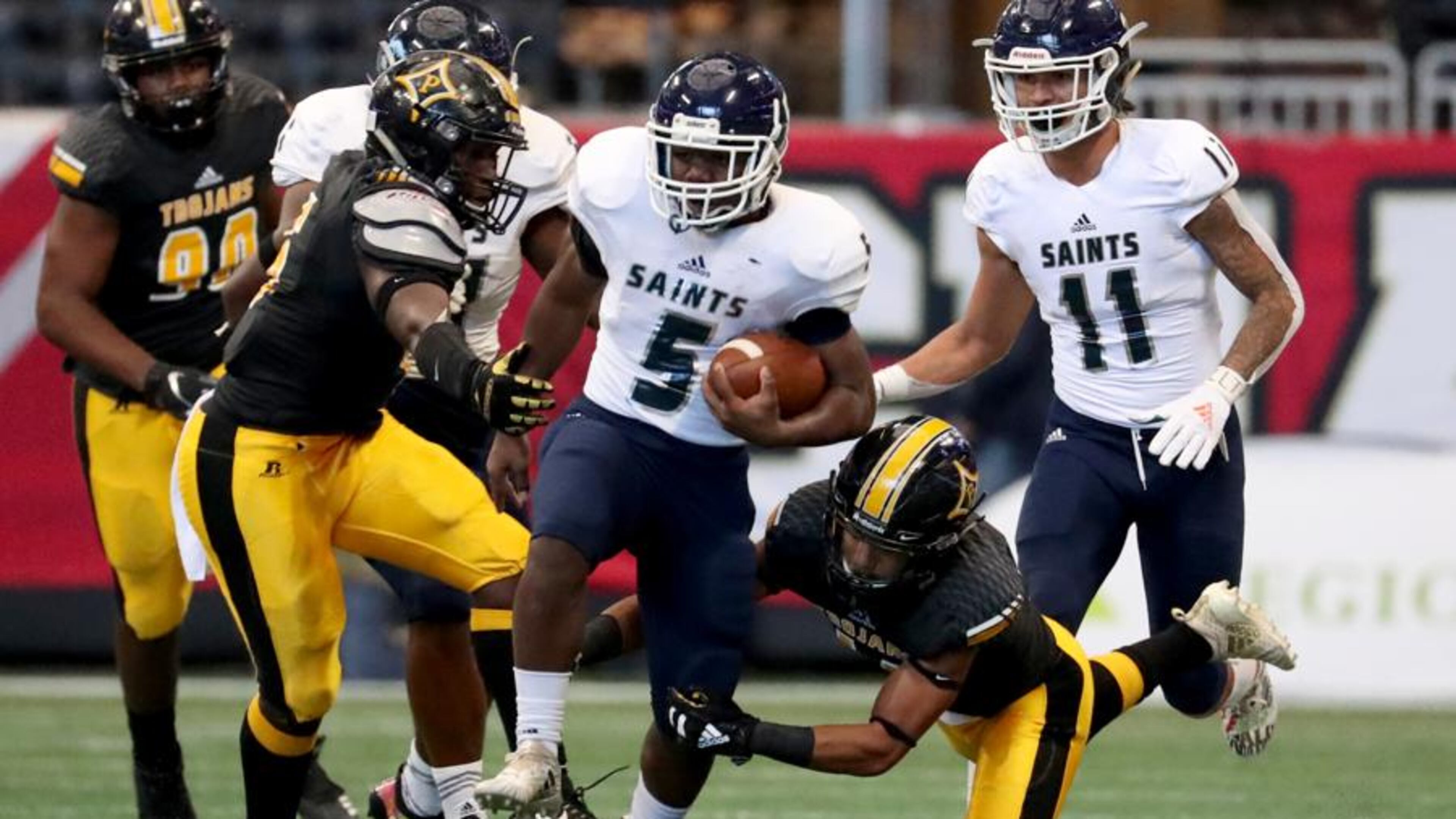 Cedar Grove running back Chavon Wright (5) runs against Peach County defenders in the first half of the Class AAA State Championship at Mercedes-Benz Stadium in Atlanta. (Jason Getz/Special to the AJC)