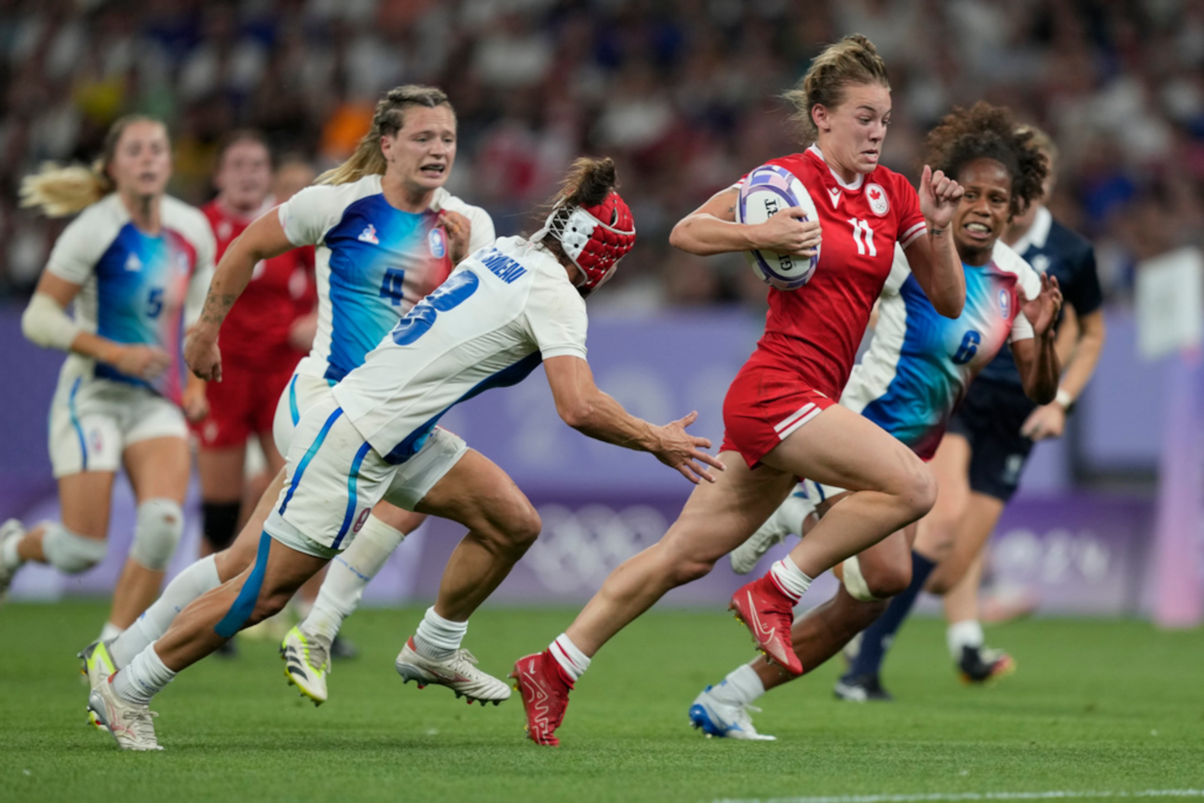 Canada's Piper Logan drives on to score a try during the women's quarterfinal Rugby Sevens match between France and Canada at the 2024 Summer Olympics, in the Stade de France, in Saint-Denis, France, Monday, July 29, 2024. (AP Photo/Tsvangirayi Mukwazhi)