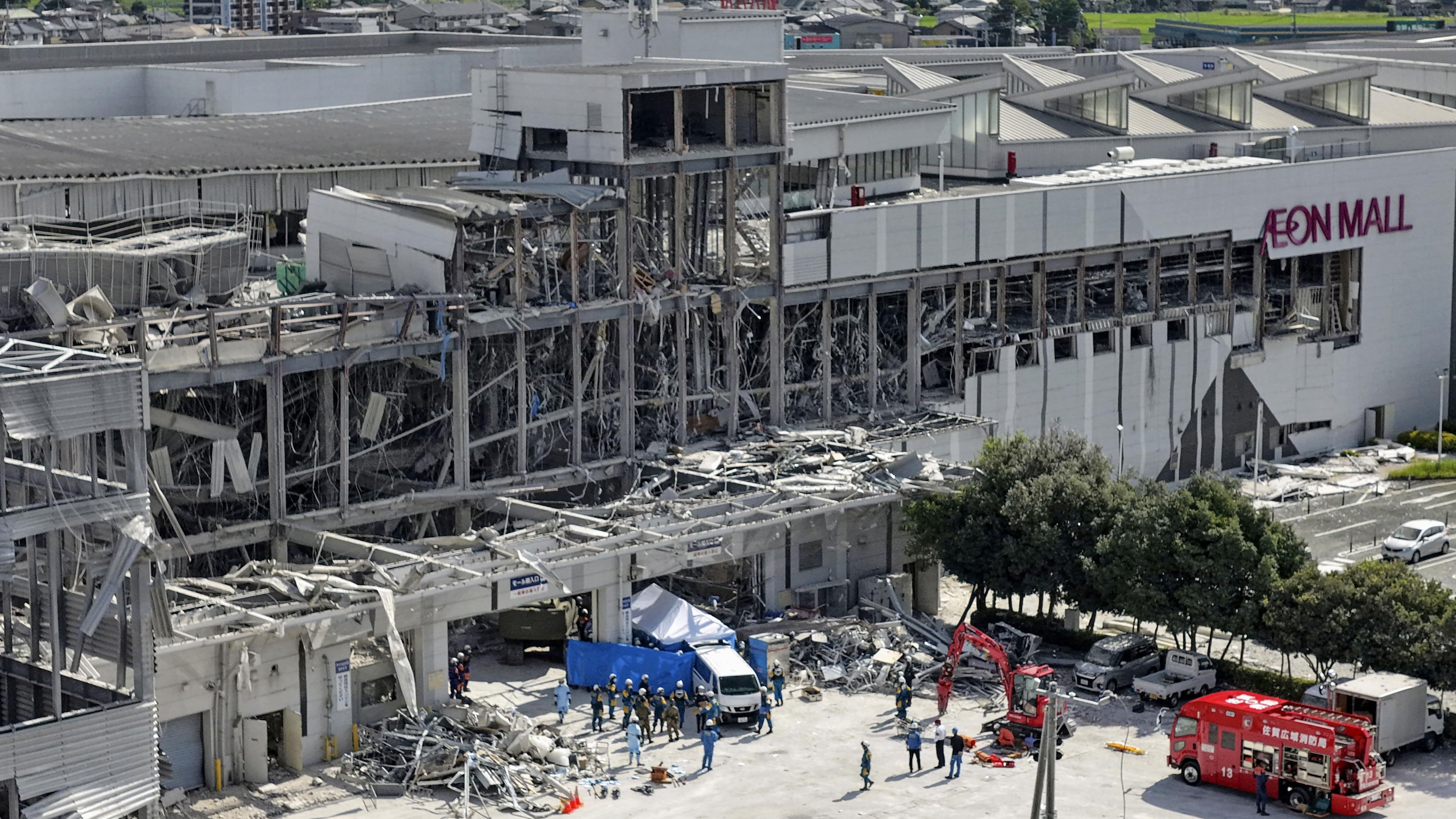 In this aerial image taken with a drone, responders work outside AEON Mall Kumamoto after an explosion occurred following an earthquake, in Kashima, Kumamoto Prefecture, southern Japan, Thursday, July 30, 2026. (Koji Harada/Kyodo News via AP)