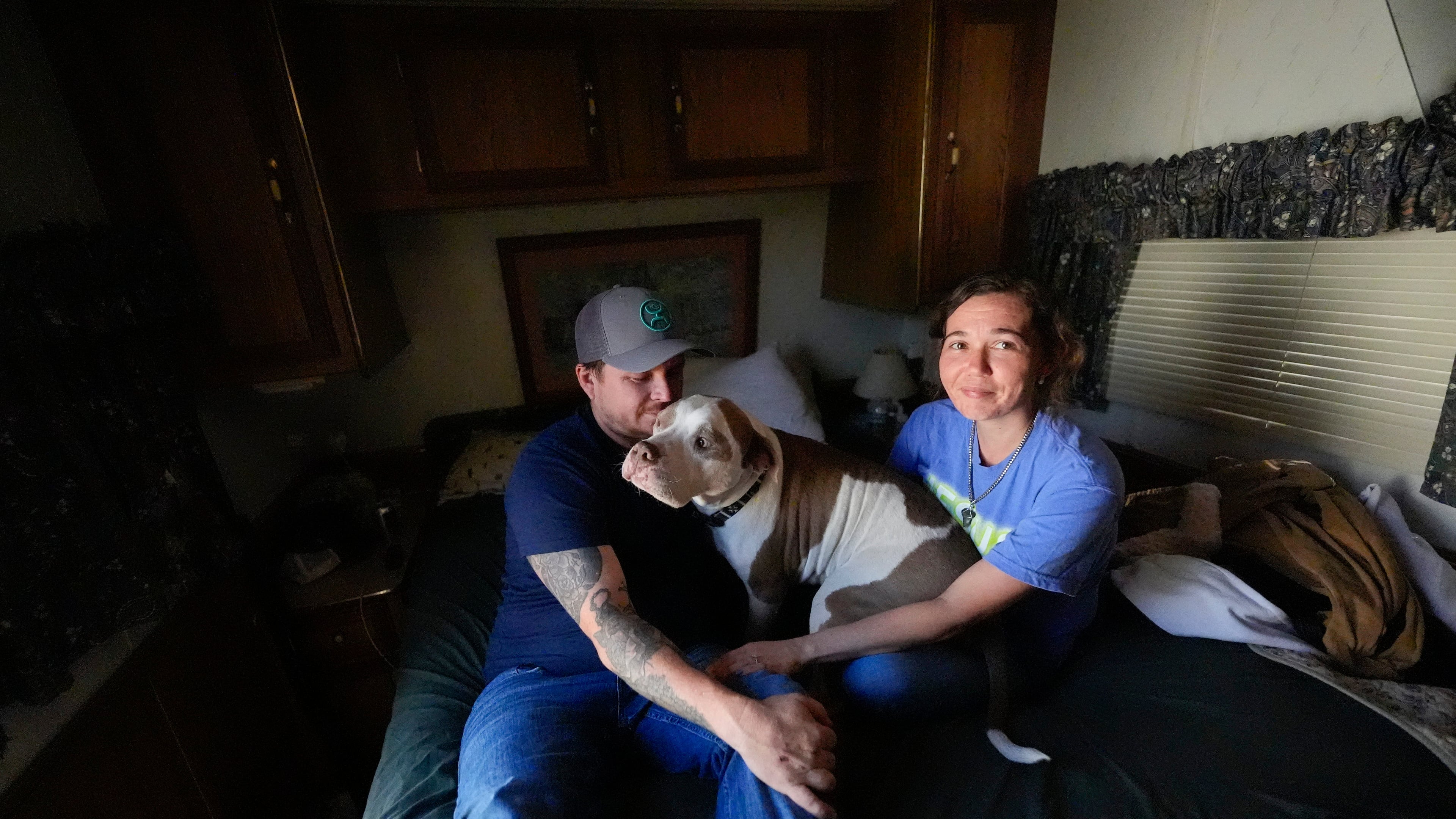 Michael Gibson and his fiancée Tabitha Enke sit inside their camper after losing their home during the Brantley Highway 82 fire, Friday, April 24, 2026, in Nahunta, Ga. (AP Photo/Mike Stewart)