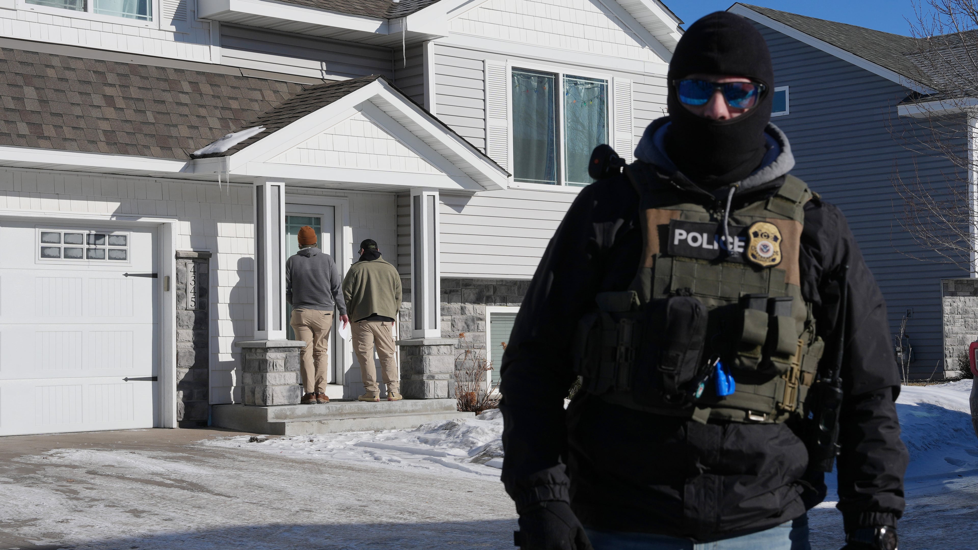 Federal agents knock on a door of a residence on Wednesday, Jan. 28, 2026, in Blaine, Minn. (AP Photo/Adam Gray)