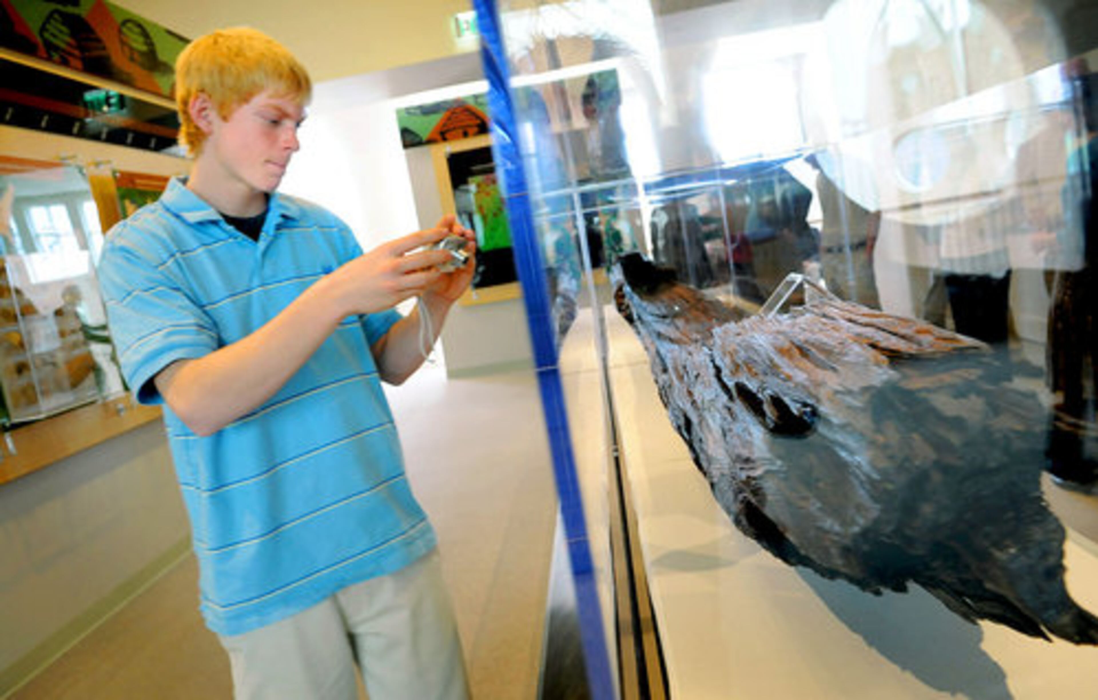 Michael Landon (left) photographs the canoe during preview reception at the museum.