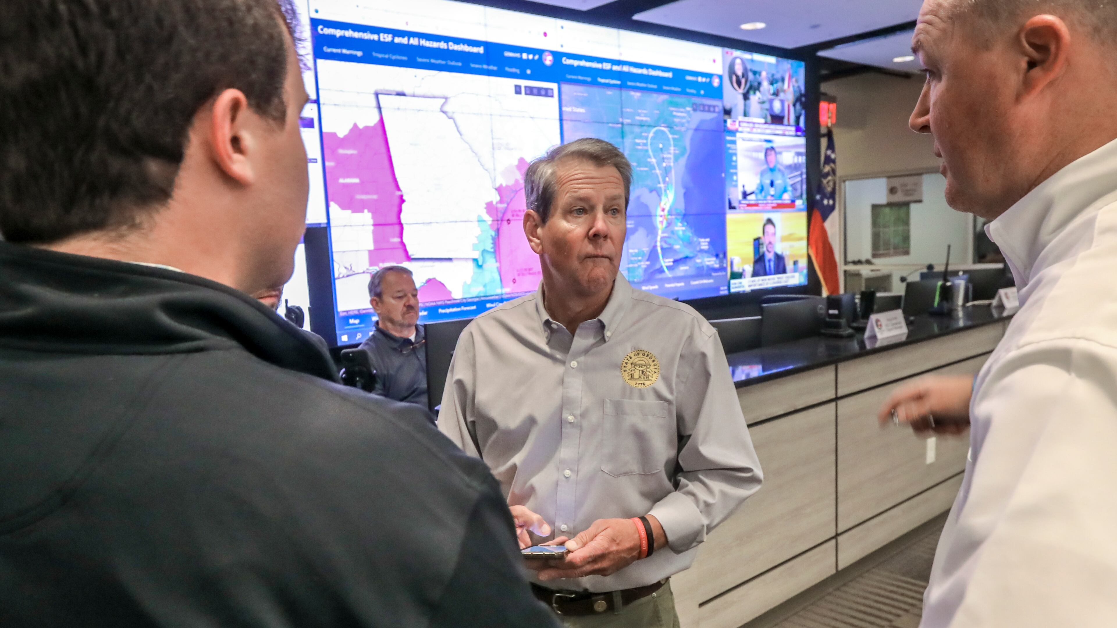 Gov. Brian Kemp talks with meteorologist Will Lanxton (left) and director Chris Stallings (right) while touring the Georgia Emergency Management and Homeland Security Agency on Sept. 28, 2022. (John Spink / AJC)