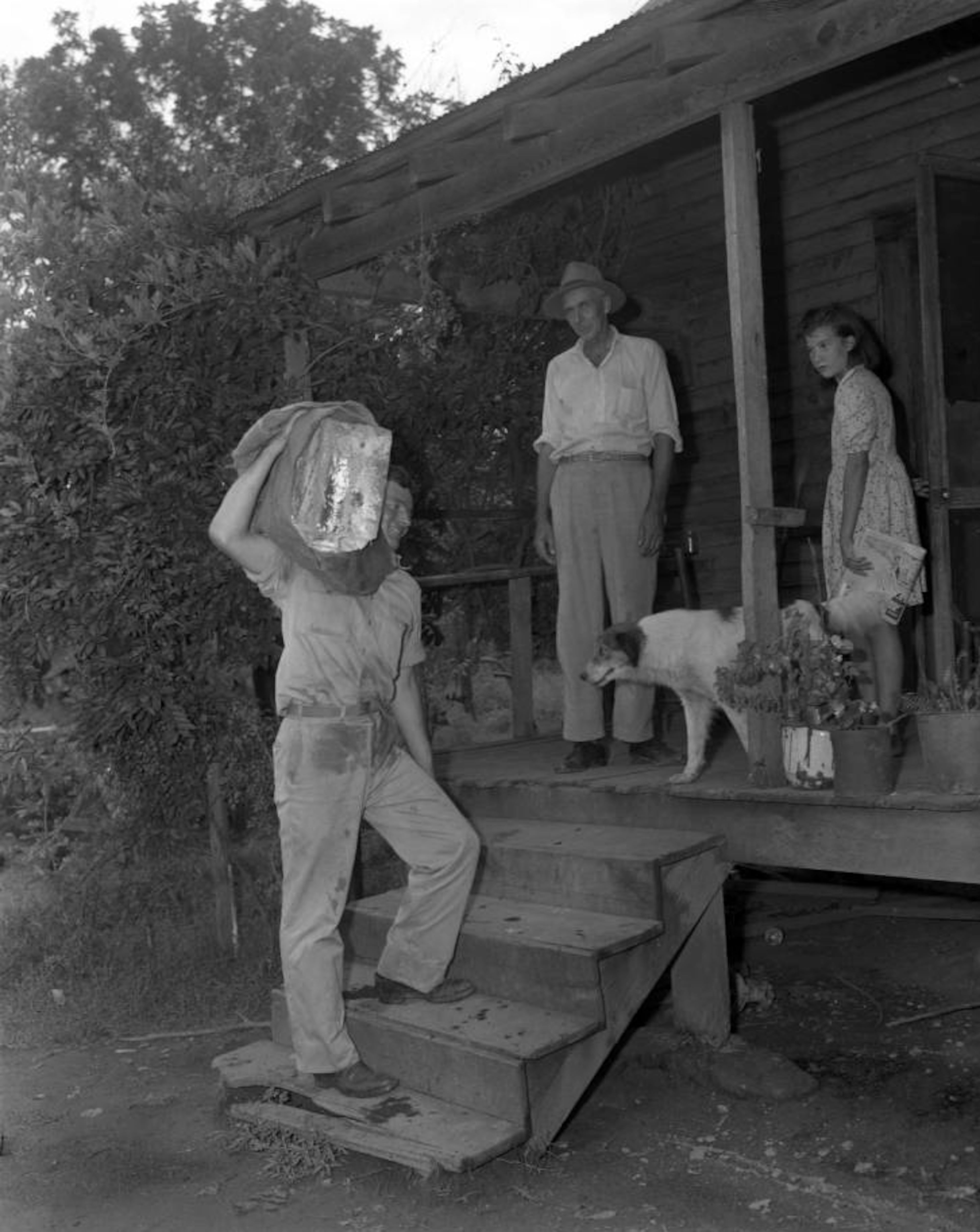 Iceman Thomas Weller delivers ice to a family's doorstep in September 1945.
